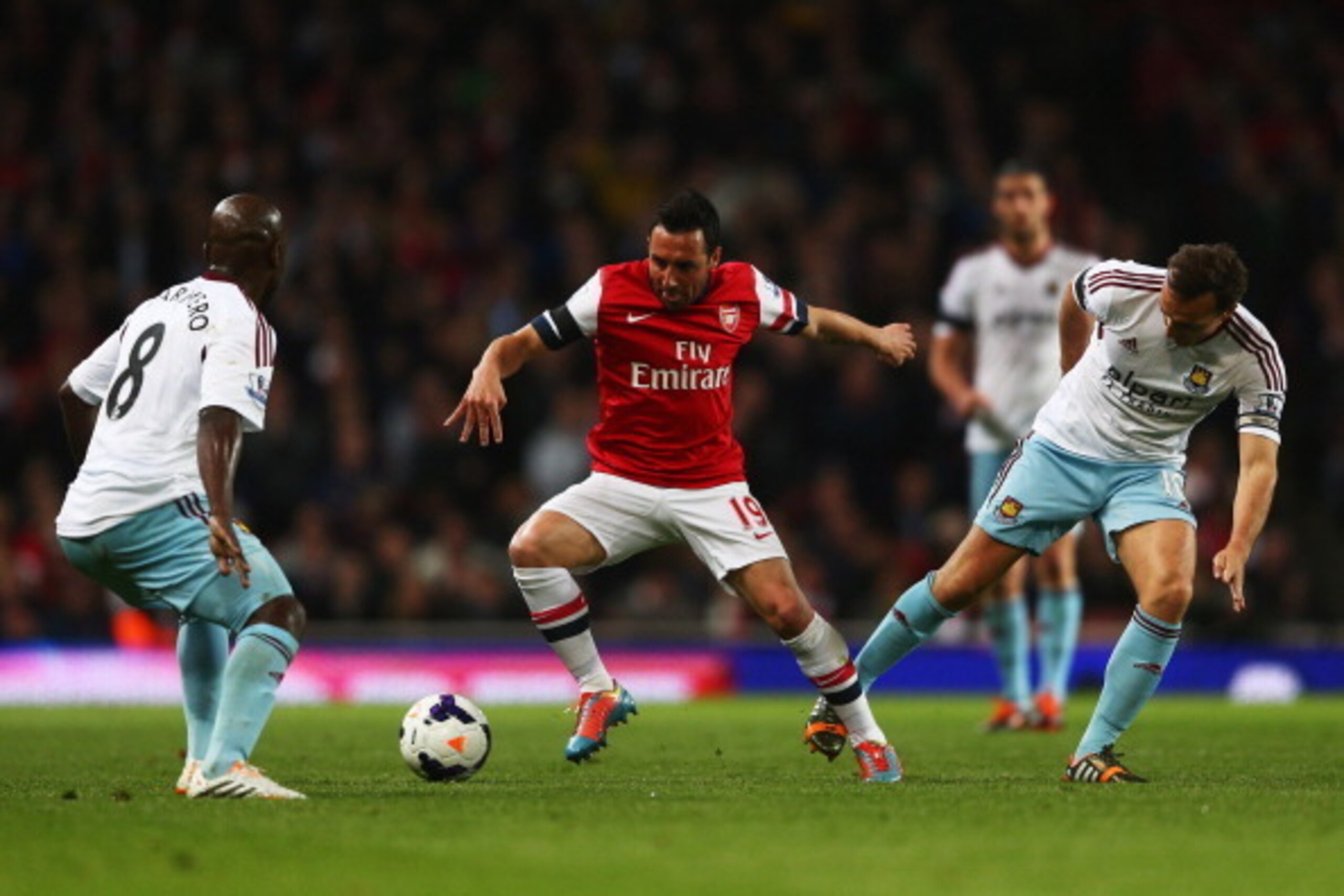 LONDON, ENGLAND - APRIL 15:  Santi Cazorla of Arsenal (C) takes on Pablo Armero (L) and Mark Noble of West Ham United (R) during the Barclays Premier League match between Arsenal and West Ham United at Emirates Stadium on April 15, 2014 in London, England