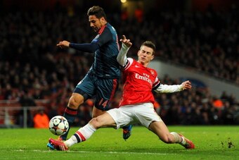 LONDON, ENGLAND - FEBRUARY 19:  Laurent Koscielny of Arsenal tackles Claudio Pizarro of Bayern Muenchen during the UEFA Champions League Round of 16 first leg match between Arsenal and FC Bayern Muenchen at Emirates Stadium on February 19, 2014 in London,