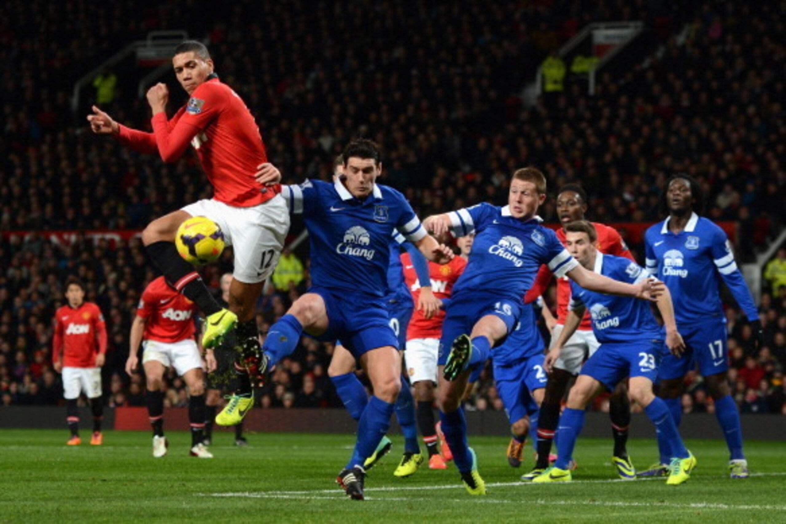 MANCHESTER, ENGLAND - DECEMBER 04:  Chris Smalling of Manchester United competes with Gareth Barry of Everton during the Barclays Premier League match between Manchester United and Everton at Old Trafford on December 4, 2013 in Manchester, England.  (Phot