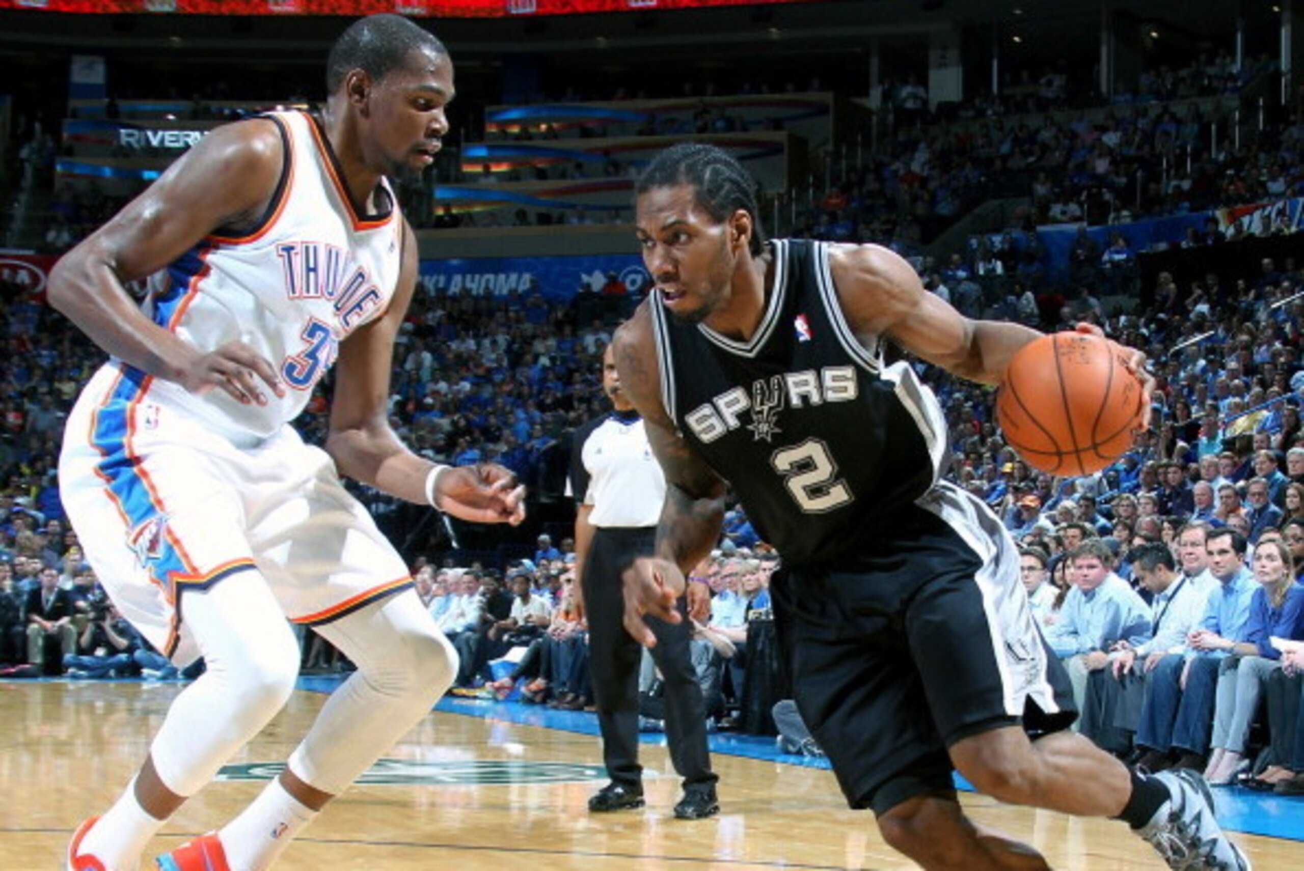 OKLAHOMA CITY, OK - APRIL 03: Kawhi Leonard #2 of the San Antonio Spurs drives against Kevin Durant #35 of the Oklahoma City Thunder on April 03, 2014 at the Chesapeake Energy Arena in Oklahoma City, Oklahoma. NOTE TO USER: User expressly acknowledges and