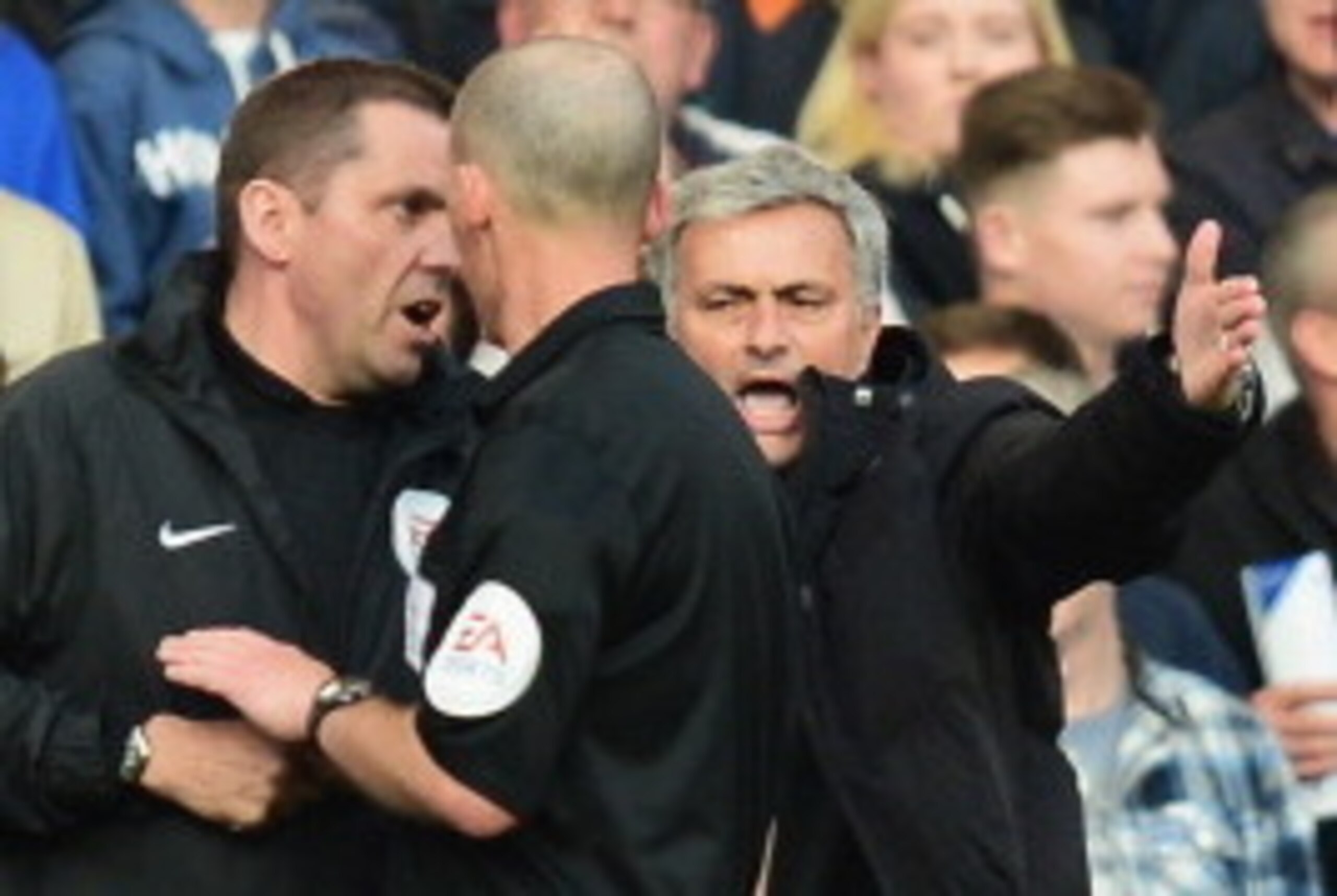 LONDON, ENGLAND - APRIL 19:  Chelsea manager Jose Mourinho talks to match referee Mike Dean and the fourth official during the Barclays Premier League match between Chelsea and Sunderland at Stamford Bridge on April 19, 2014 in London, England.  (Photo by
