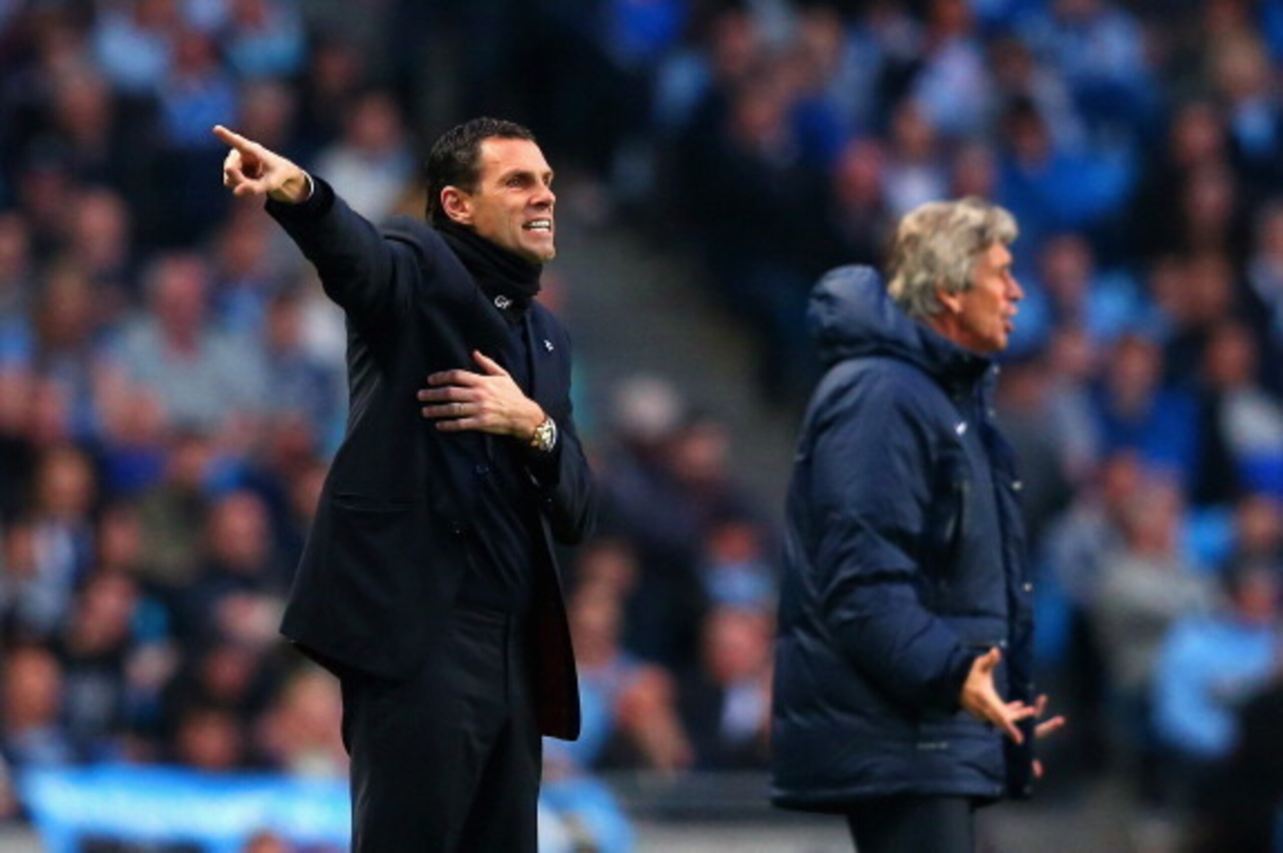 MANCHESTER, ENGLAND - APRIL 16:  Manager Gustavo Poyet of Sunderland and Manuel Pellegrini manager of Manchester City give instructions on the touchline during the Barclays Premier League match between Manchester City and Sunderland at Etihad Stadium on A