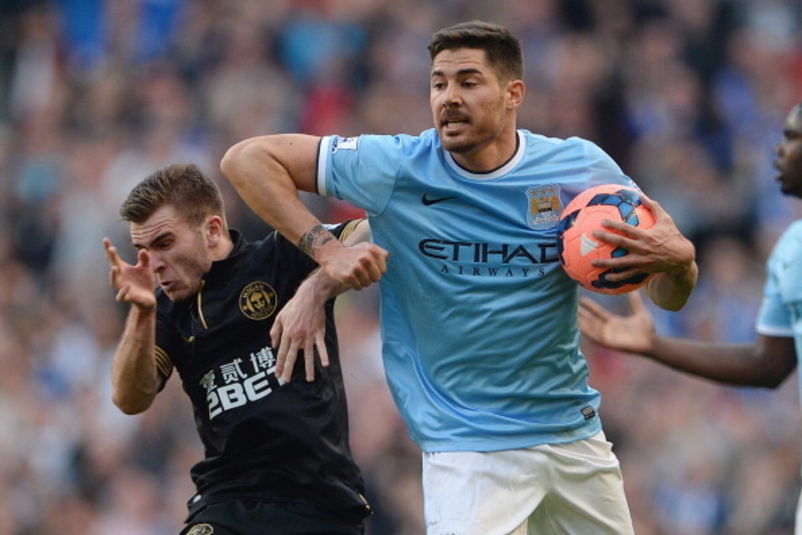 MANCHESTER, ENGLAND - MARCH 09: Javi Garcia of Man City clashes with Callum McManaman oif Wigan during the FA Cup Quarter-Final match between Manchester City and Wigan Athletic at the Etihad Stadium on March 9, 2014 in Manchester, England.  (Photo by Mich