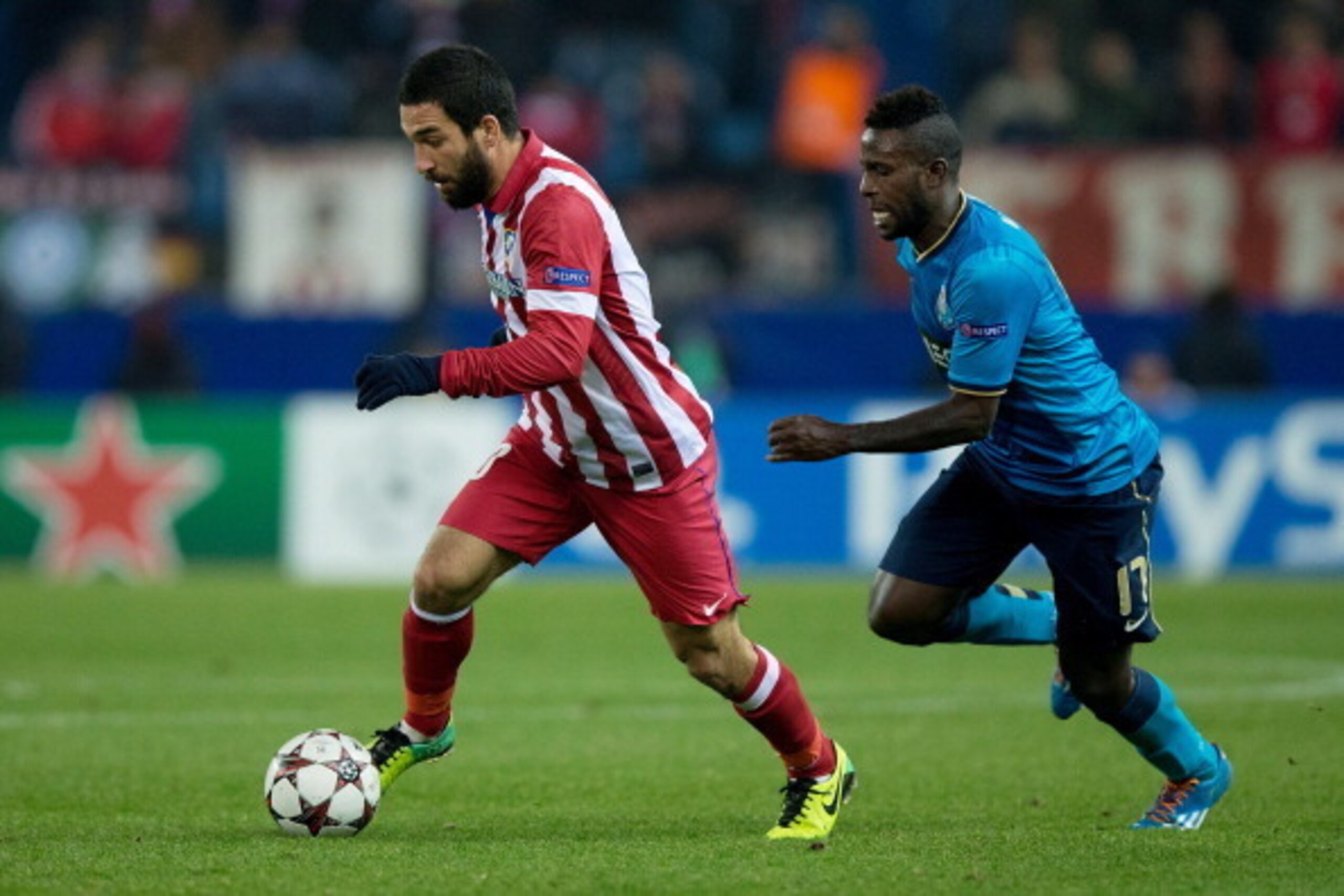 MADRID, SPAIN - DECEMBER 11: Arda Turan (L) of Atletico de Madrid  competes for the ball with  Silvestre Varela (R) of FC Porto during the UEFA Champions League Group G match at Vicente Calderon Stadium on December 11, 2013 in Madrid, Spain.  (Photo by Go