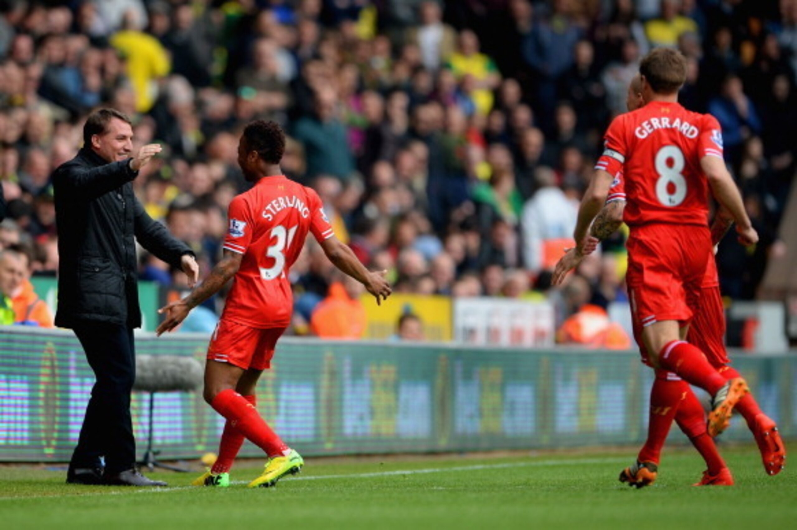 NORWICH, ENGLAND - APRIL 20:  Raheem Sterling of Liverpool celebrates scoring the opening goal with Manager Brendan Rodgers of Liverpool during the Barclays Premier League match between Norwich City and Liverpool at Carrow Road on April 20, 2014 in Norwic