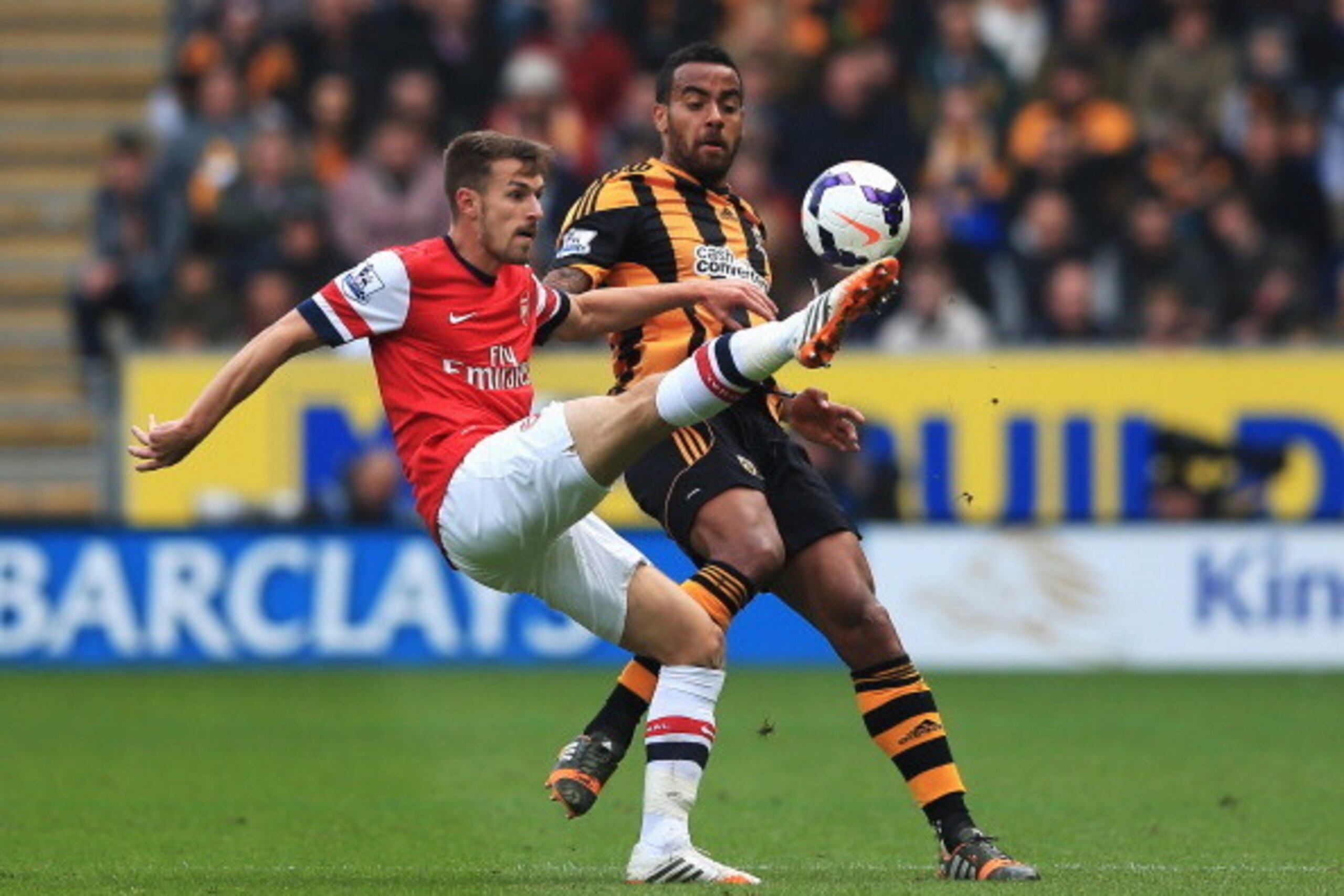 HULL, ENGLAND - APRIL 20:  (L-R) Aaron Ramsey of Arsenal and Tom Huddlestone of Hull City challenge for the ball during the Barclays Premier League match between Hull City and Arsenal at KC Stadium on April 20, 2014 in Hull, England.  (Photo by Matthew Le