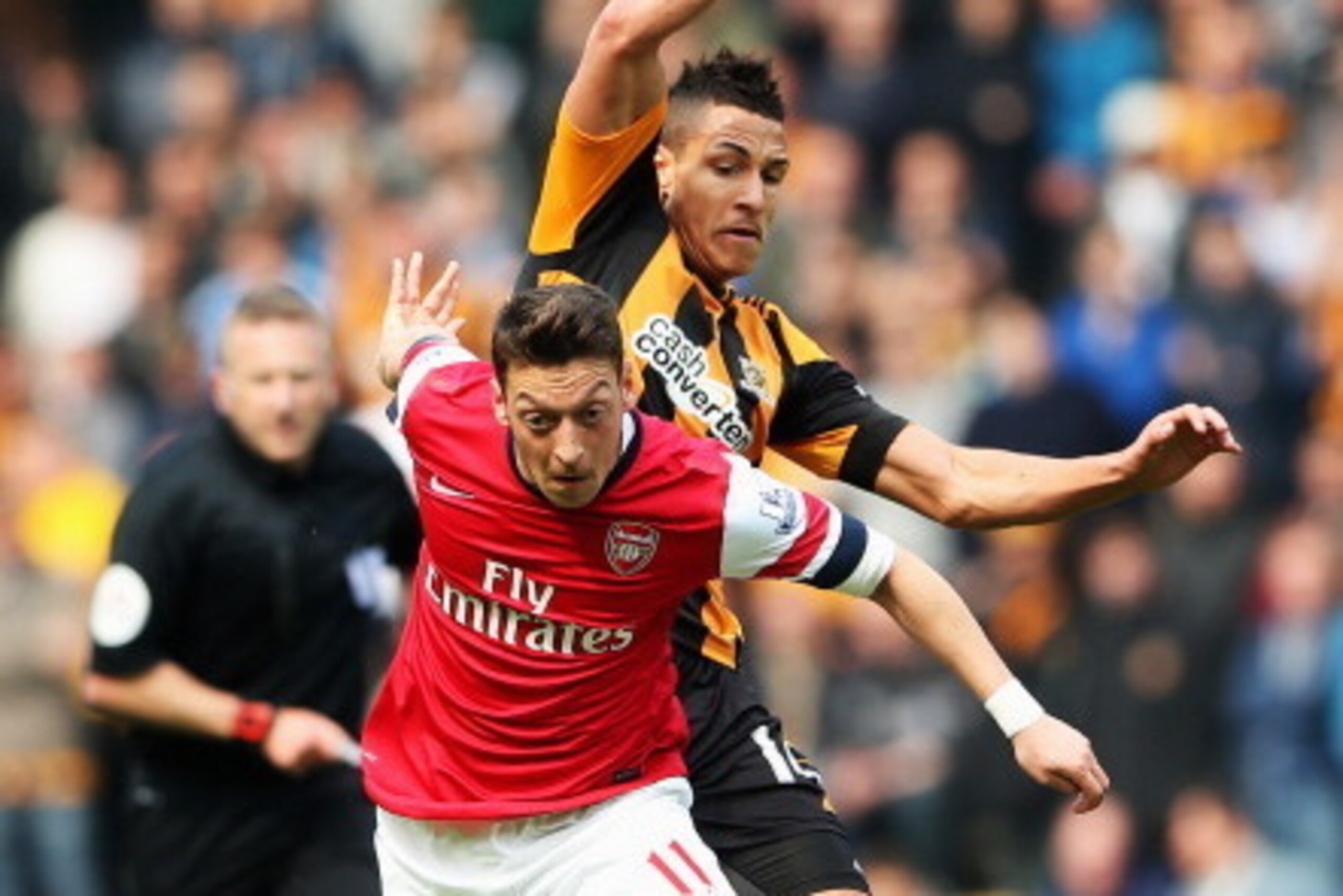 HULL, ENGLAND - APRIL 20:  Mesut Oezil (L) of Arsenal holds off Jake Livermore (R) of Hull City during the Barclays Premier League match between Hull City and Arsenal at KC Stadium on April 20, 2014 in Hull, England.  (Photo by Scott Heavey/Getty Images)