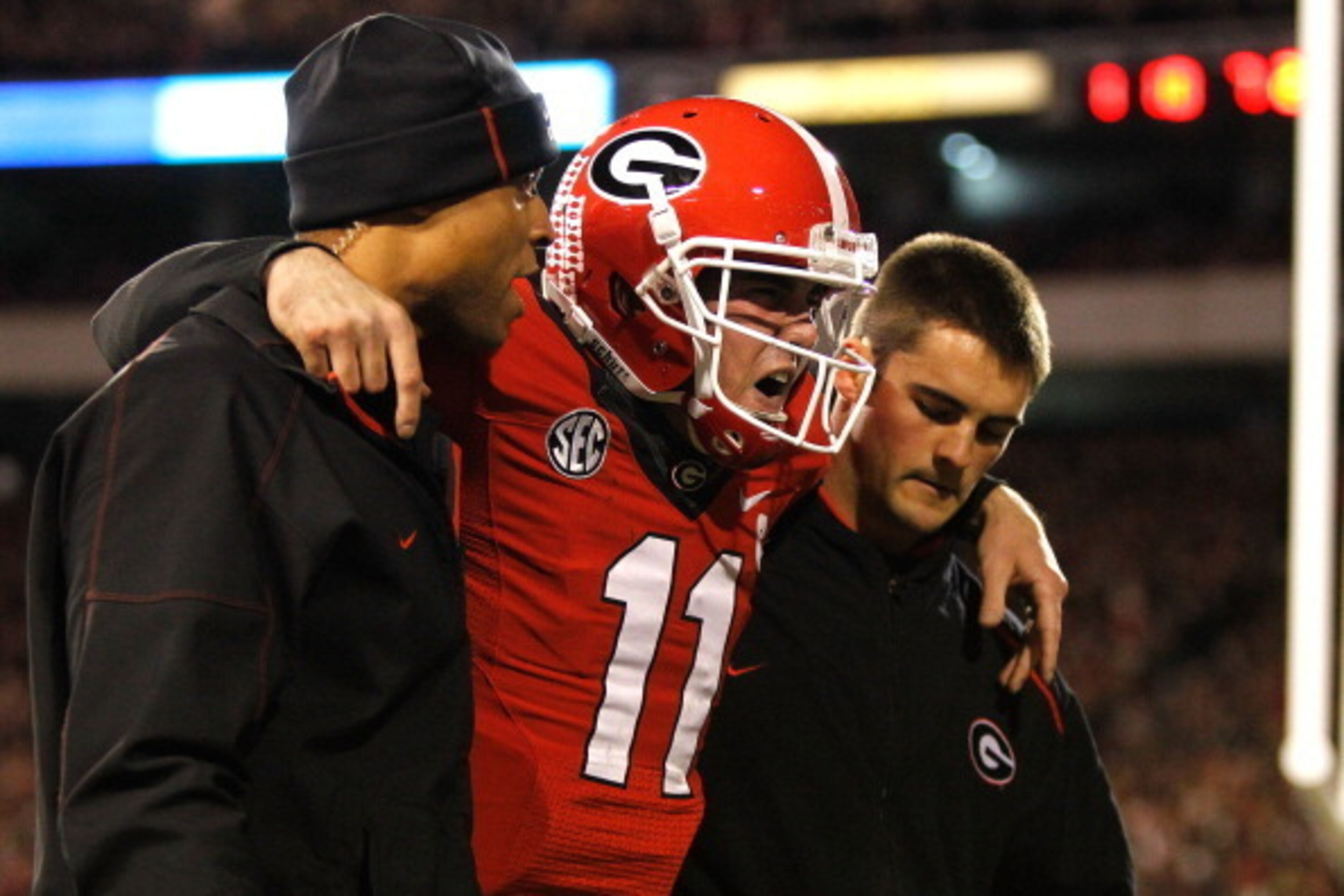 ATHENS, GA - NOVEMBER 23:  Quarterback Aaron Murray #11 of the Georgia Bulldogs is escorted off of the field by members of his coaching staff after getting injured during the game against the Kentucky Wildcats at Sanford Stadium on November 23, 2013 in At