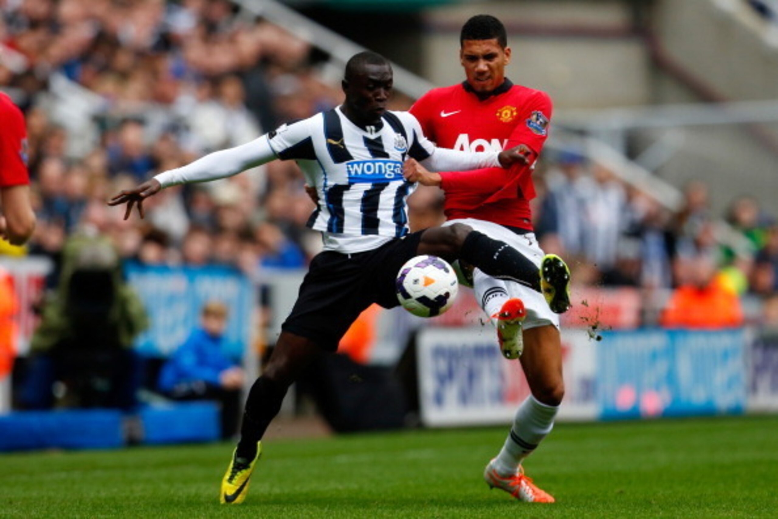 NEWCASTLE UPON TYNE, ENGLAND - APRIL 05: Papiss Demba Cisse (L) of Newcastle in action with Chris Smalling of Manchester United during the Barclays Premier League match between Newcastle United and Manchester United at St James' Park on April 5, 2014 in N