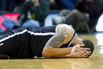 Feb 19, 2014; Salt Lake City, UT, USA; Brooklyn Nets point guard Deron Williams (8) reacts to being injured during the second half against the Utah Jazz at EnergySolutions Arena. The Nets won 105-99. Mandatory Credit: Russ Isabella-USA TODAY Sports