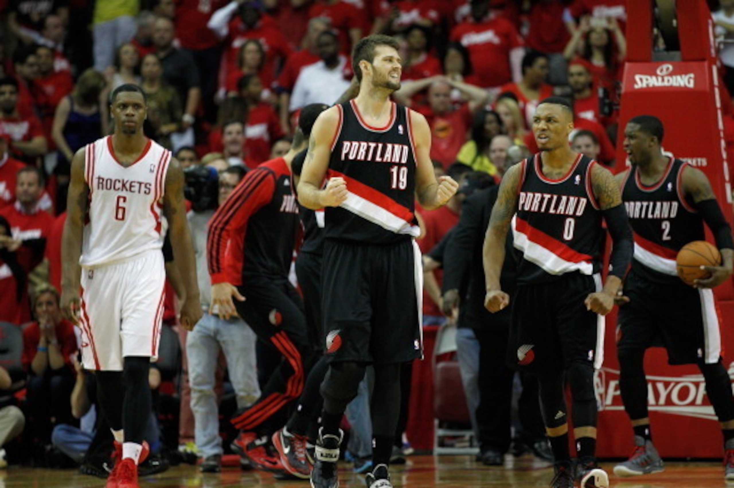 HOUSTON, TX - APRIL 20:  Damian Lillard #0 of the Portland Trail Blazers and Joel Freeland #19 celebrate their win in overtime over the Houston Rockets in Game One of the Western Conference Quarterfinals during the 2014 NBA Playoffs at the Toyota Center o