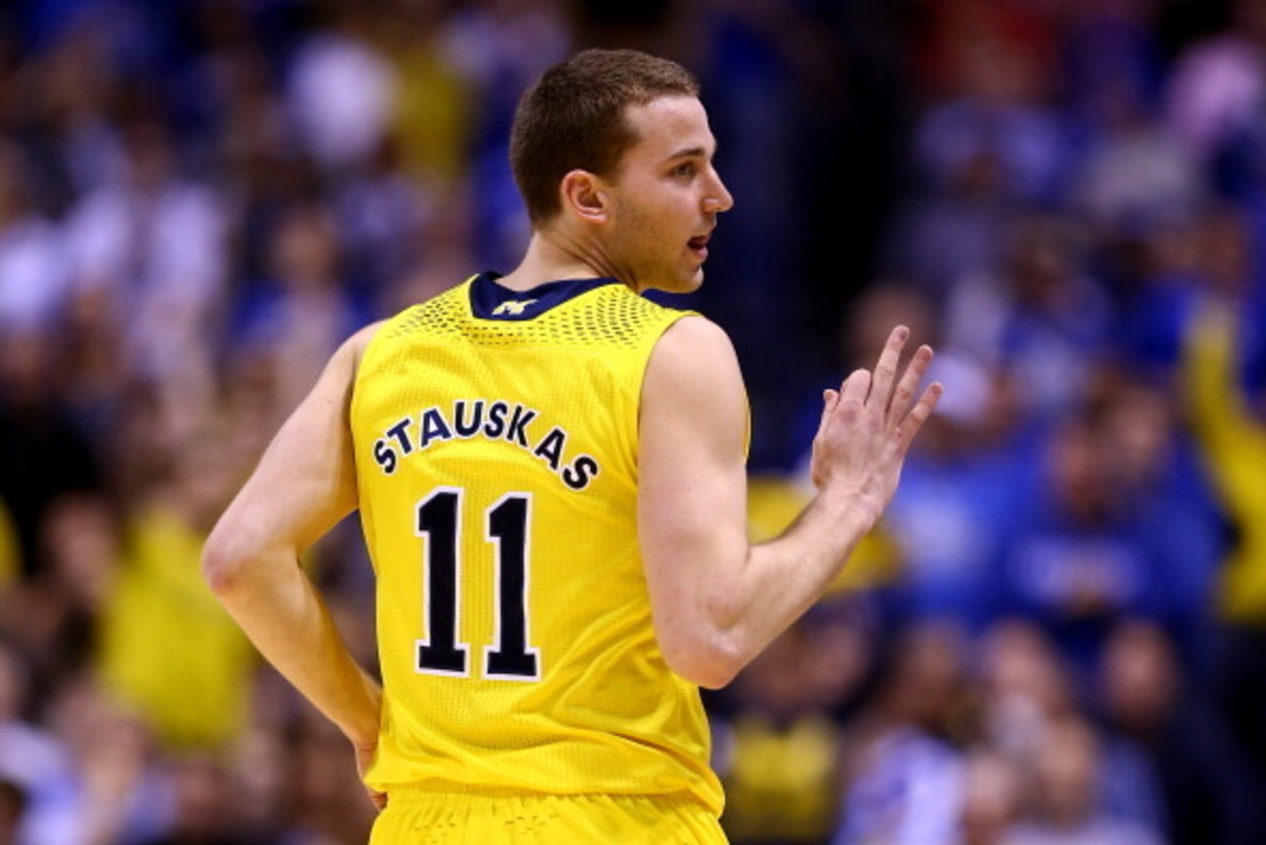 INDIANAPOLIS, IN - MARCH 30:  Nik Stauskas #11 of the Michigan Wolverines celebrates a three pointer in the first half against the Kentucky Wildcats during the midwest regional final of the 2014 NCAA Men's Basketball Tournament at Lucas Oil Stadium on Mar