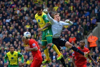 NORWICH, ENGLAND - APRIL 20: Simon Mignolet of Liverpool fails to punch the ball clear during the Barclays Premier League match between Norwich City and Liverpool at Carrow Road on April 20, 2014 in Norwich, England.  (Photo by Michael Regan/Getty Images)