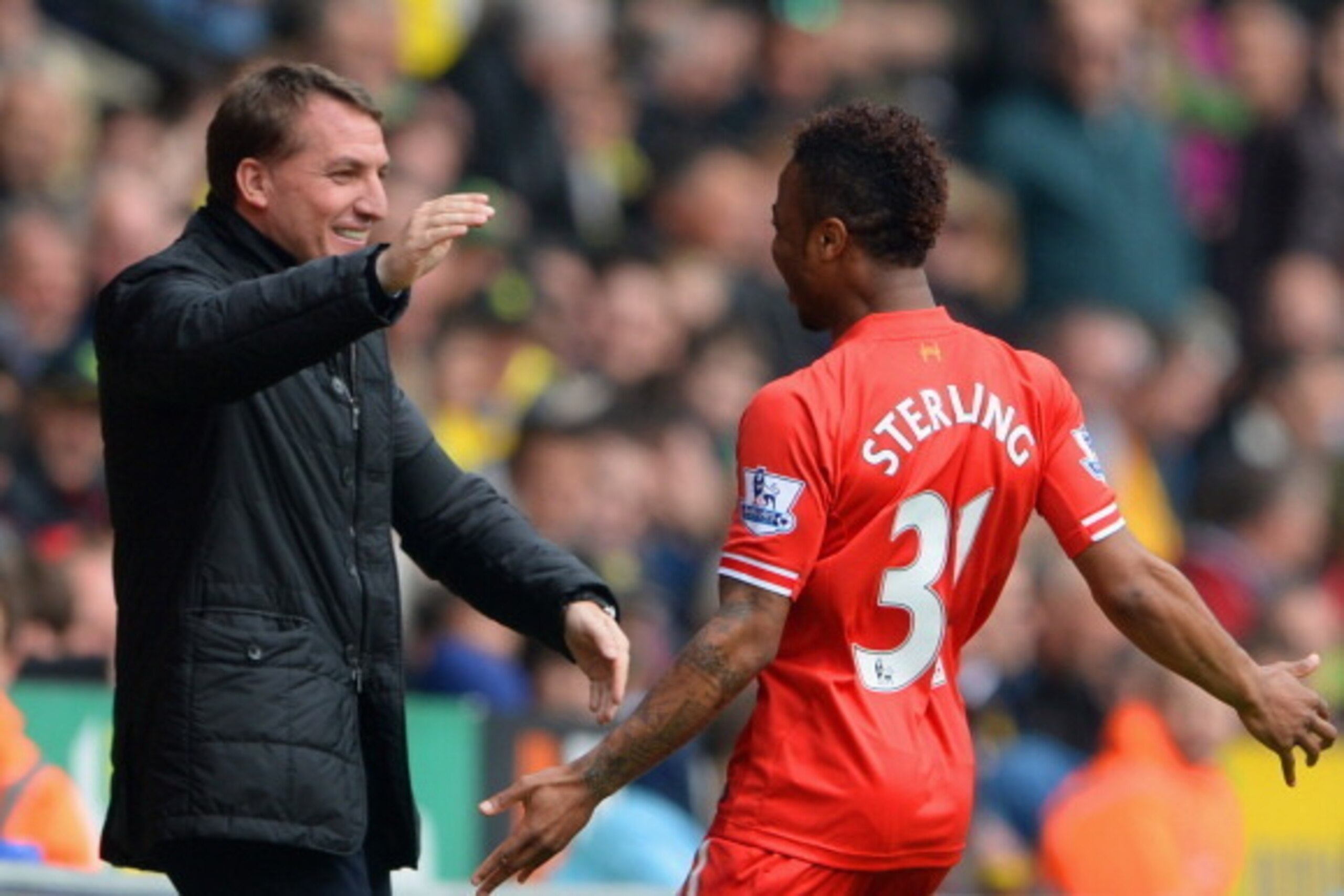 NORWICH, ENGLAND - APRIL 20:  Raheem Sterling of Liverpool celebrates scoring the opening goal with Manager Brendan Rodgers of Liverpool during the Barclays Premier League match between Norwich City and Liverpool at Carrow Road on April 20, 2014 in Norwic