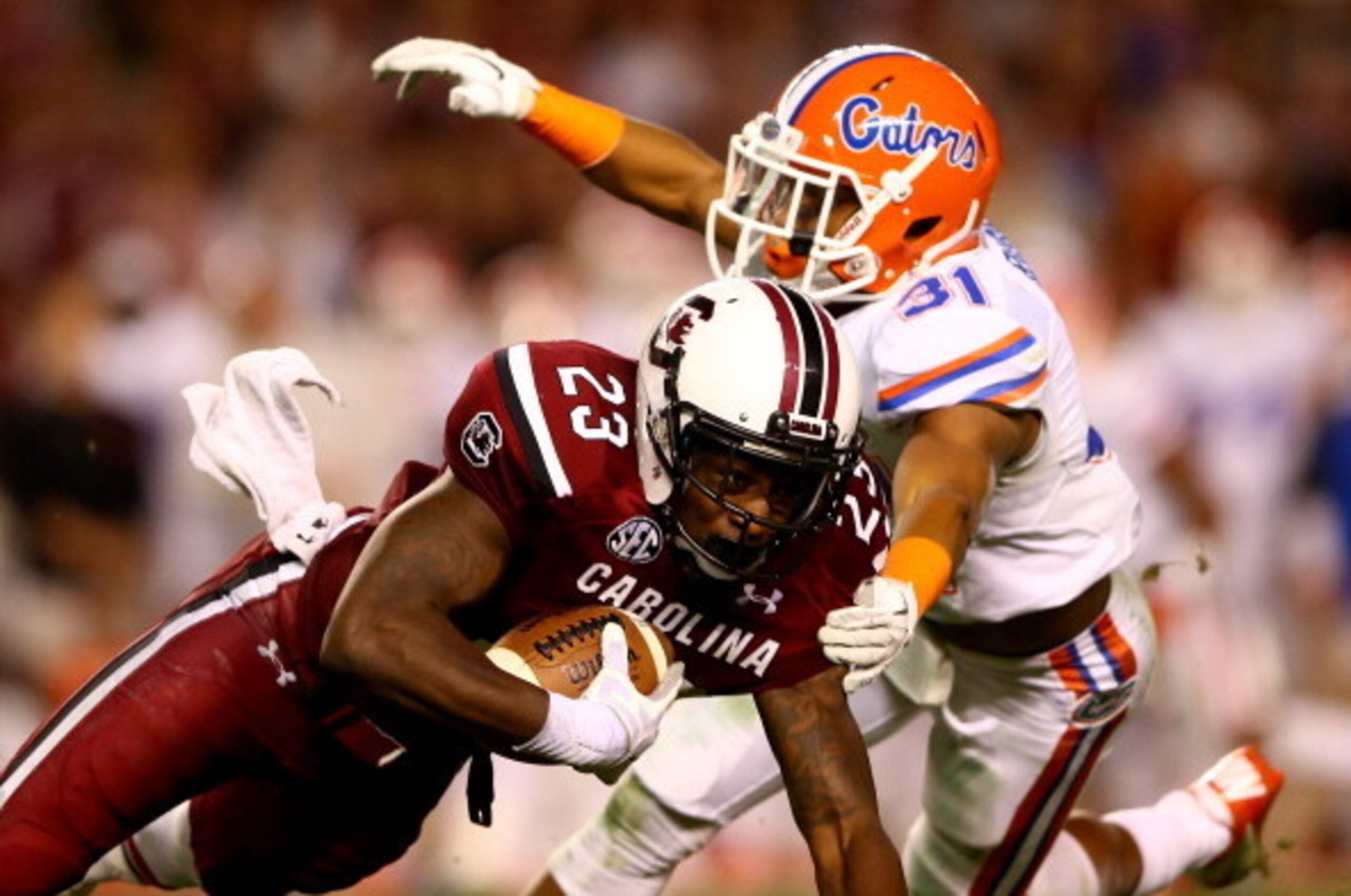 COLUMBIA, SC - NOVEMBER 16:  Bruce Ellington #23 of the South Carolina Gamecocks runs with the ball as Cody Riggs #31 of the Florida Gators tries to make a tackle during their game at Williams-Brice Stadium on November 16, 2013 in Columbia, South Carolina