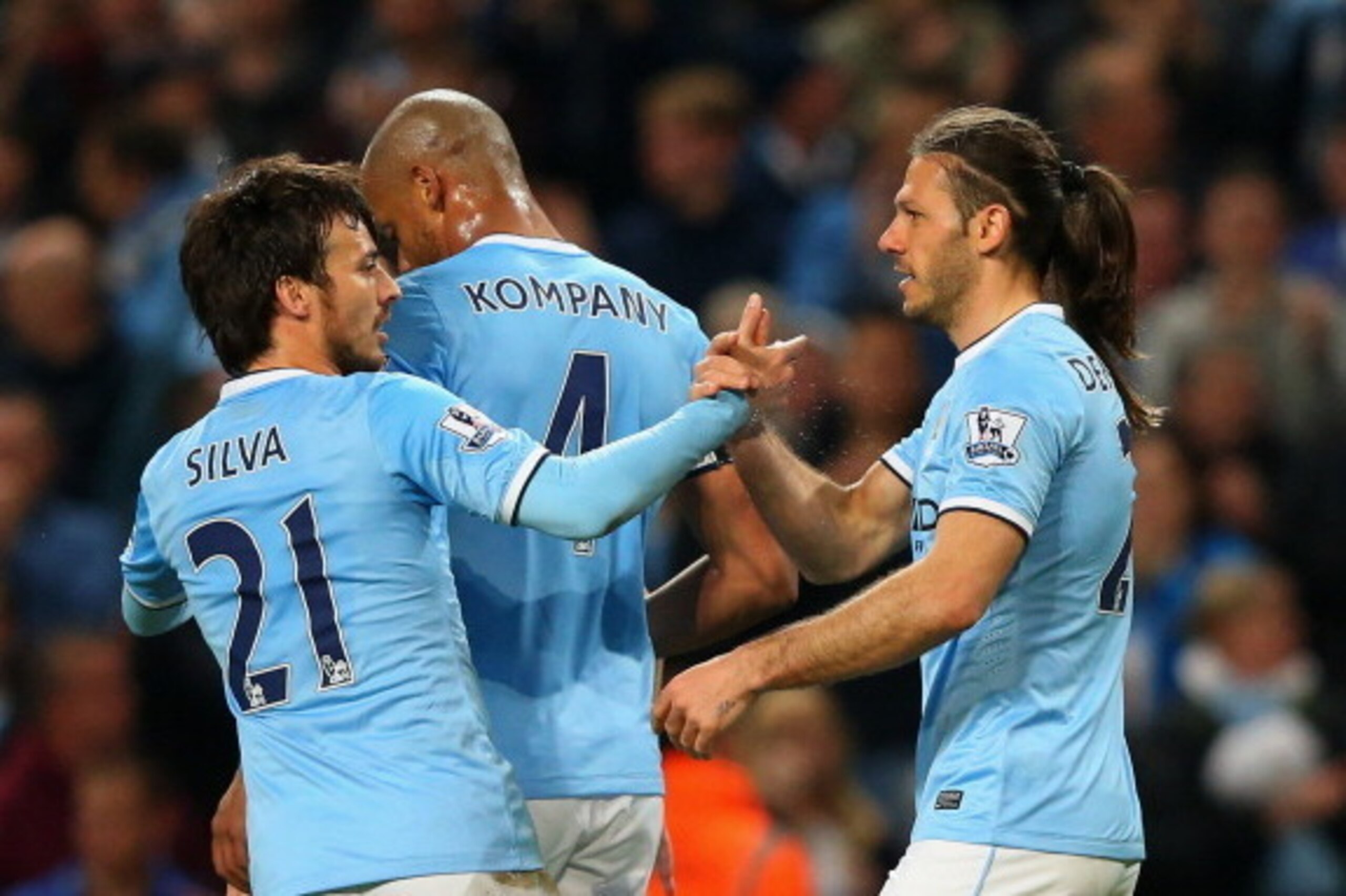MANCHESTER, ENGLAND - APRIL 21:  Martin Demichelis of Manchester City (R) celebrates with David Silva (21) and Vincent Kompany (4) as he scores their third goal during the Barclays Premier League match between Manchester City and West Bromwich Albion at E