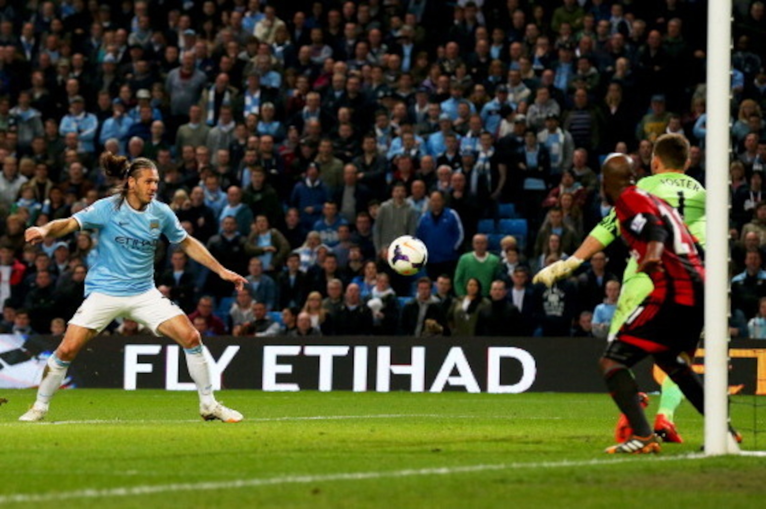 MANCHESTER, ENGLAND - APRIL 21:  Martin Demichelis of Manchester City (L) scores their third goal past goalkeeper Ben Forster of West Bromwich Albion during the Barclays Premier League match between Manchester City and West Bromwich Albion at Etihad Stadi