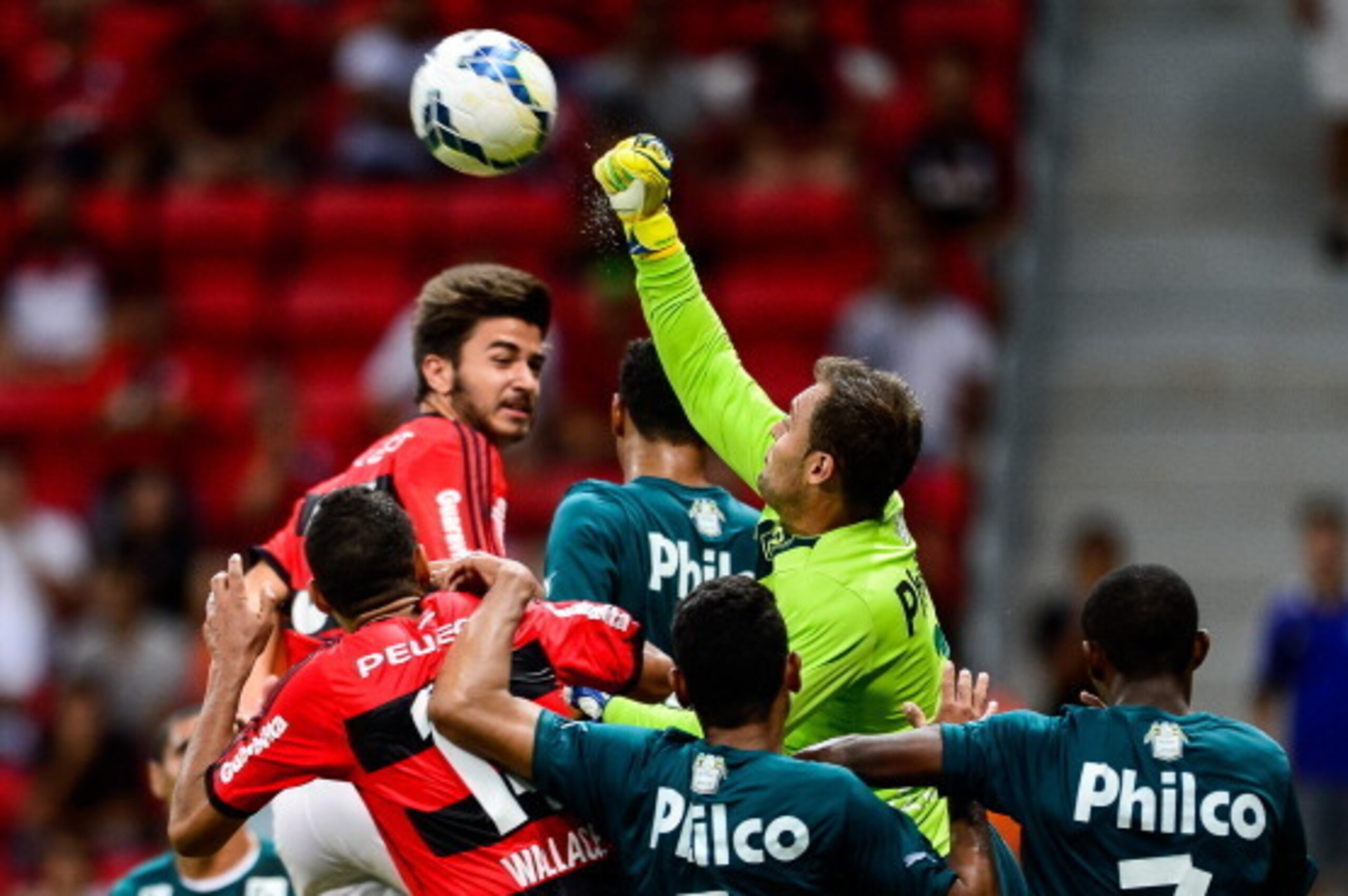 BRASILIA, BRAZIL - APRIL 20: Wallace (L) and Matheus of Flamengo struggles for the ball with a goalkeeper Renan of Goias during a match between Flamengo and Goias as part of Brasileirao Series A 2014  at Mane Garrincha Stadium on April 20, 2014 in Brasili
