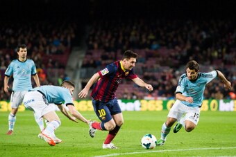 BARCELONA, SPAIN - MARCH 26: Lionel Messi (C) of FC Barcelona runs with the ball between Andreu Fontas (L) and Jonathan Castro 'Jonny' of RC Celta de Vigo during the La Liga match between FC Barcelona and RC Celta de Vigo at Camp Nou on March 26, 2014 in 