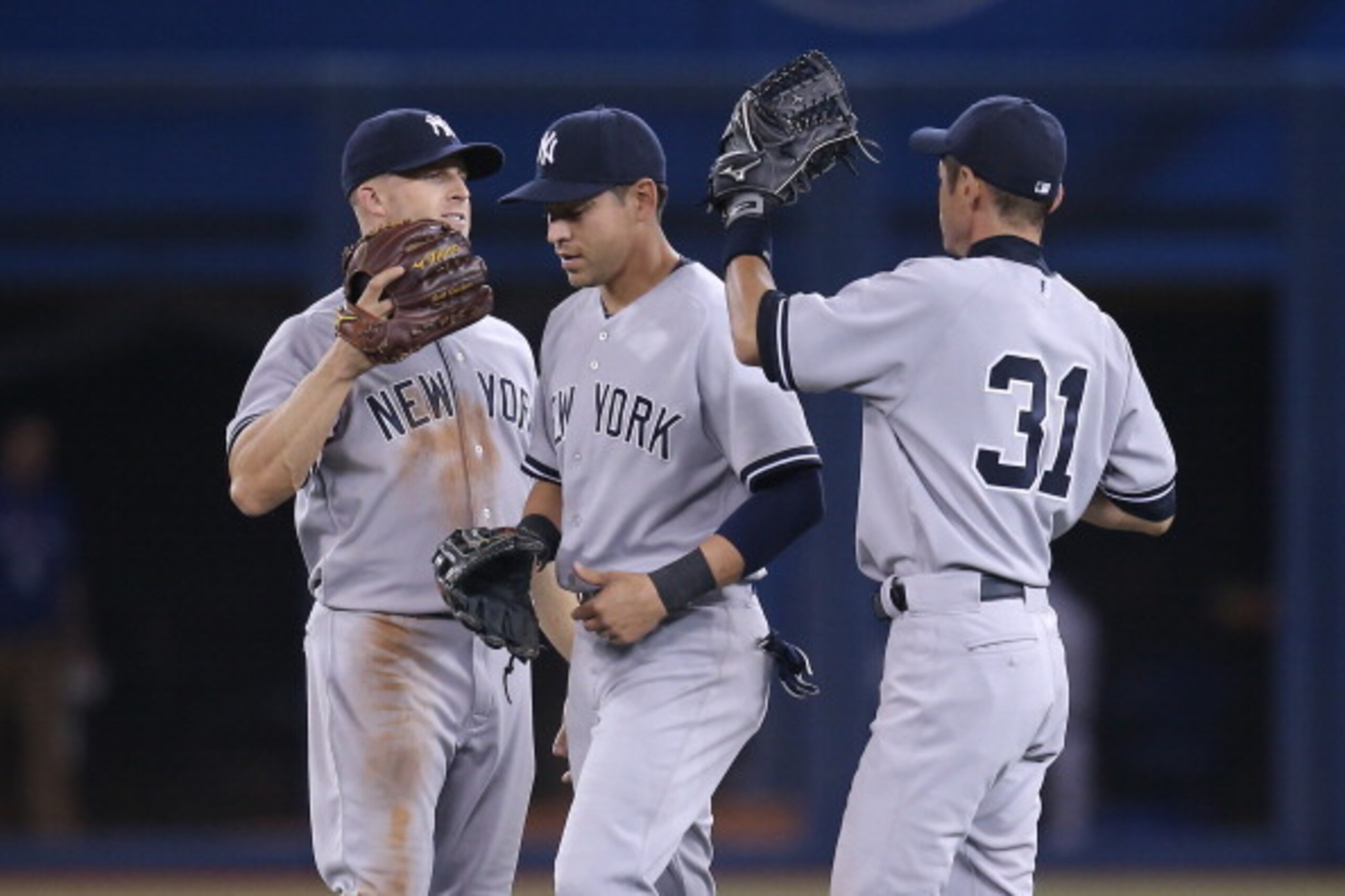 TORONTO, CANADA - APRIL 6: Brett Gardner #11 of the New York Yankees celebrates their victory with Ichiro Suzuki #31 and Jacoby Ellsbury #22 during MLB game action against the Toronto Blue Jays on April 6, 2014 at Rogers Centre in Toronto, Ontario, Canada