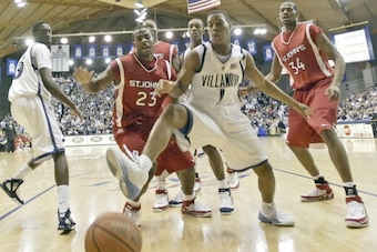 St. John's Ryan Williams (23) and Villanova's Kyle Lowry (1) look to grab a loose ball Wednesday, March 1, 2006 at The Pavilion in Villanova, PA. Villanova University defeated St. John's University 65-52. (Photo by Drew Hallowell/Getty Images)