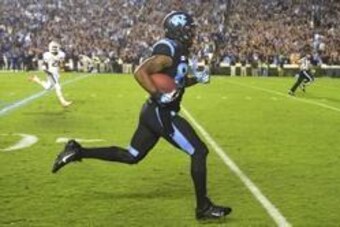 Oct 17, 2013; Chapel Hill, NC, USA; North Carolina Tar Heels tight end Eric Ebron (85) runs for a touchdown as Miami Hurricanes defensive back Antonio Crawford (21) defends in the first quarter at Kenan Memorial Stadium. Mandatory Credit: Bob Donnan-USA T