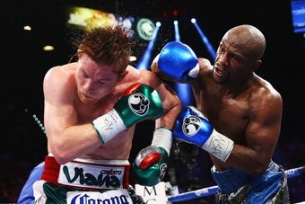 LAS VEGAS, NV - SEPTEMBER 14:  (L-R) Floyd Mayweather Jr. throws a right to Canelo Alvarez during their WBC/WBA 154-pound title fight at the MGM Grand Garden Arena on September 14, 2013 in Las Vegas, Nevada.  (Photo by Al Bello/Getty Images)