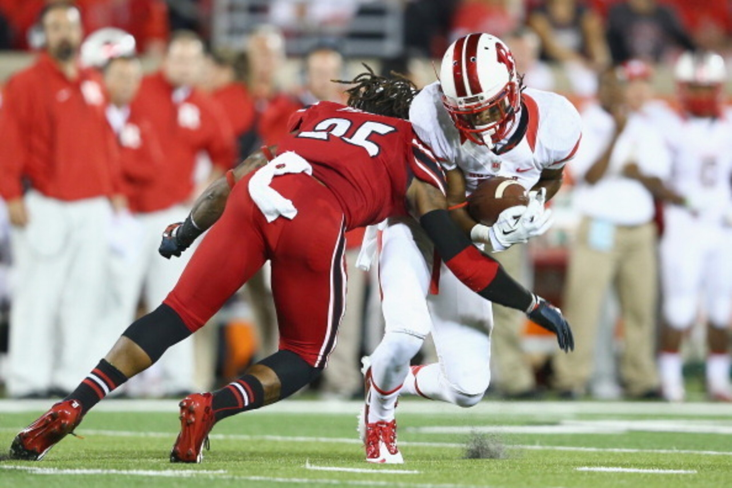 LOUISVILLE, KY - OCTOBER 10:  Quron Pratt #7 of the Rutgers Scarlet Knights is tackled by Calvin Pryor #25 of the Louisville Cardinals during the game at Papa John's Cardinal Stadium on October 10, 2013 in Louisville, Kentucky.  (Photo by Andy Lyons/Getty