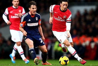 LONDON, ENGLAND - JANUARY 18:  Mesut Oezil of Arsenal evades Scott Parker of Fulham during the Barclays Premier League match between Arsenal and Fulham at Emirates Stadium on January 18, 2014 in London, England.  (Photo by Clive Mason/Getty Images)