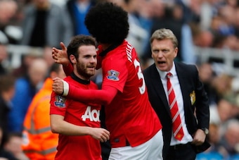 NEWCASTLE UPON TYNE, ENGLAND - APRIL 05: Juan Mata of Manchester United (L) celebrates with team mate Marouane Fellaini after scoring their first goal while Manager David Moyes (R) of Manchester United reacts during the Barclays Premier League match betwe
