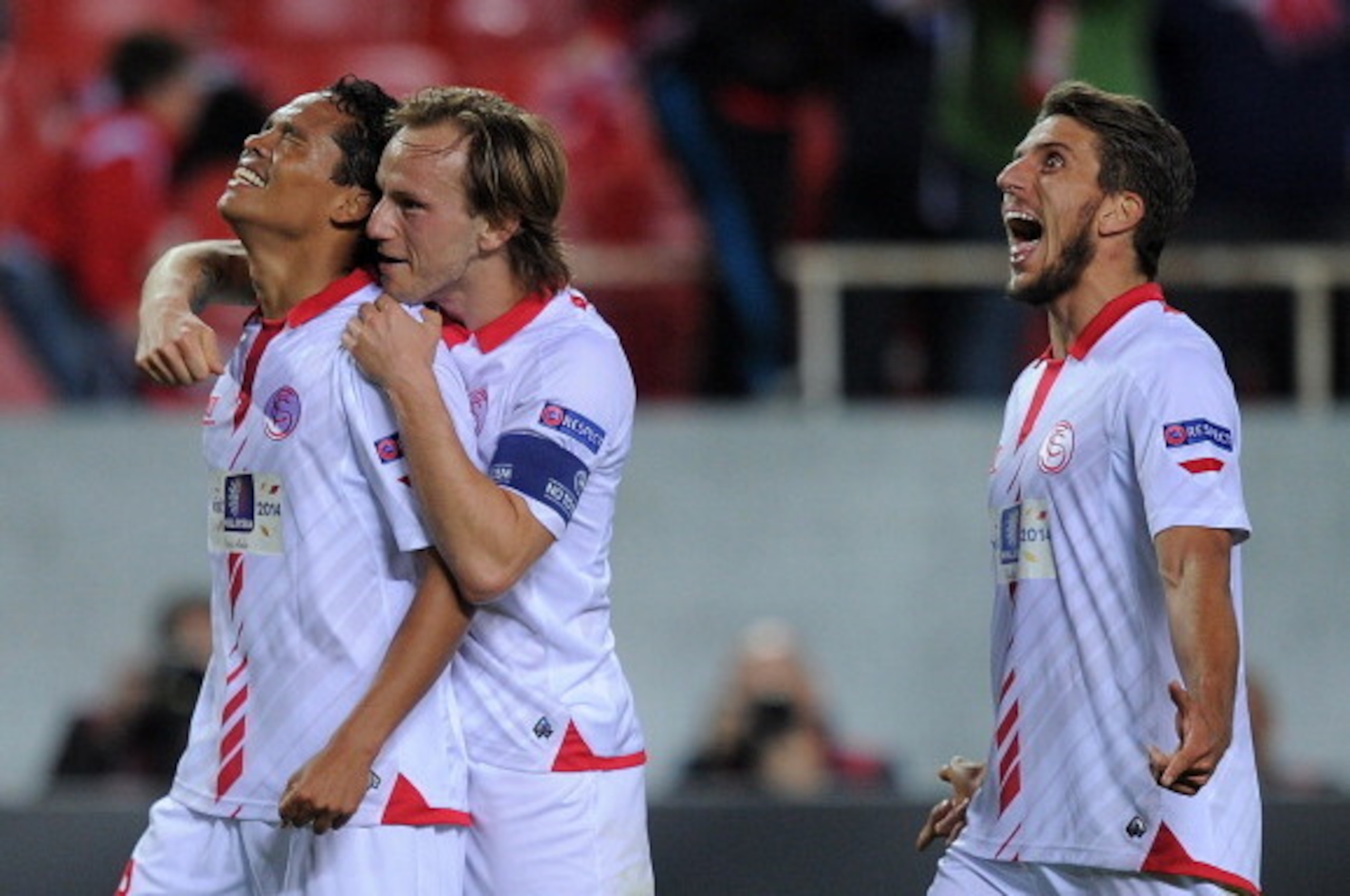 SEVILLE, SPAIN - APRIL 24:  Carlos Bacca (L) of Sevilla FC celebrates with Ivan Rakitic and Daniel Carrico after scoring Sevilla's 2nd goal during the UEFA Europa League Semi Final first leg match between Sevilla FC and Valencia CF at Estadio Ramon Sanche