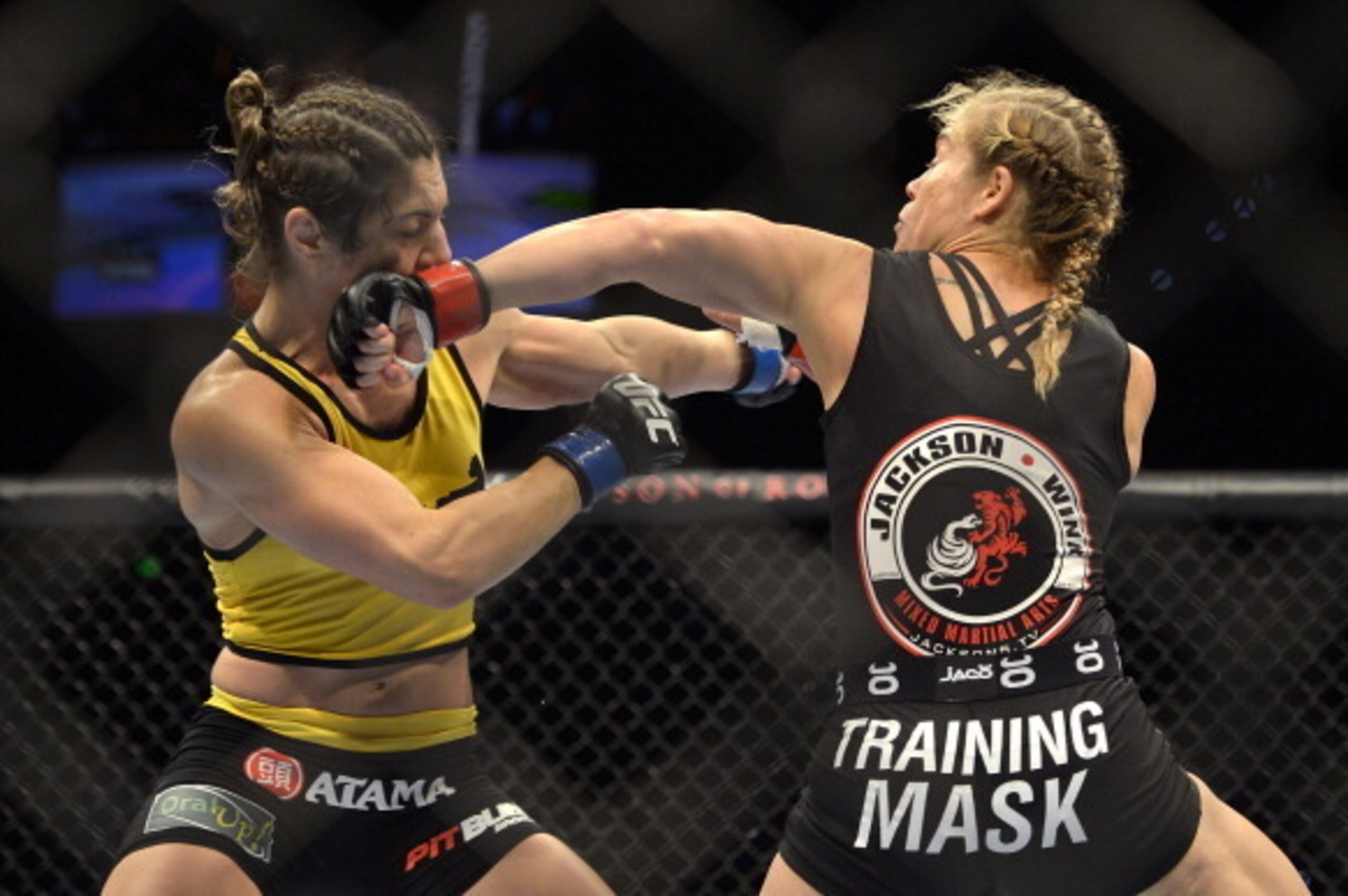 BRISBANE, AUSTRALIA - DECEMBER 07:  Julie Kedzie of the USA and Bethe Correia of Brazil trade punches during the UFC Fight Night Brisbane bout between Julie Kedzie of the USA and Bethe Correia of Brazil at Brisbane Entertainment Centre on December 7, 2013