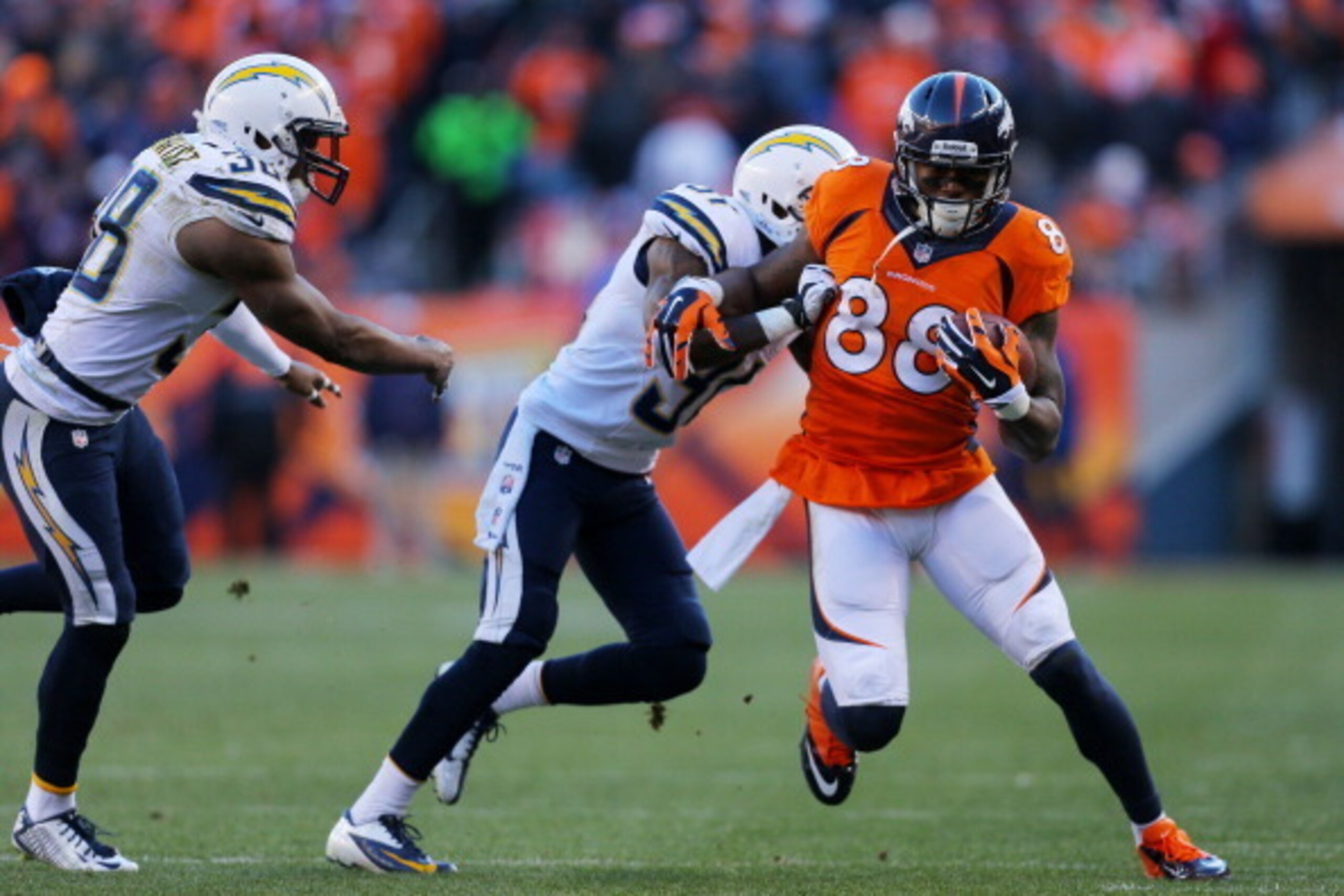 DENVER, CO - JANUARY 12:  Demaryius Thomas #88 of the Denver Broncos tries to avoid the tackle of  Richard Marshall #31 of the San Diego Chargers during the AFC Divisional Playoff Game at Sports Authority Field at Mile High on January 12, 2014 in Denver, 