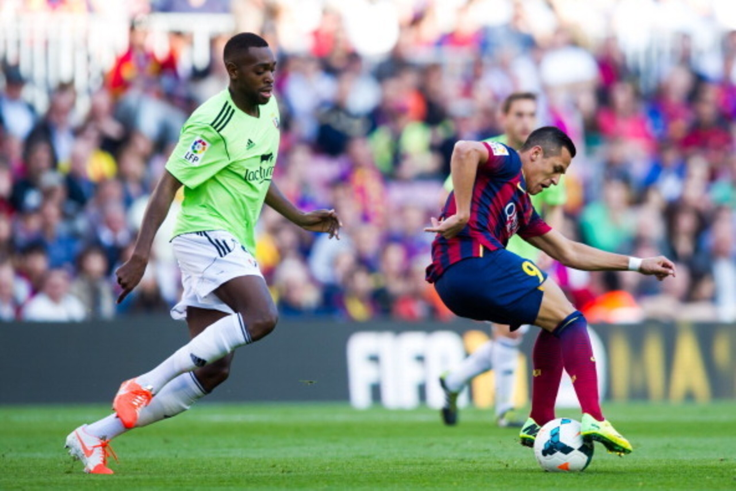BARCELONA, SPAIN - MARCH 16: Alexis Sanchez of FC Barcelona controls the ball in front of Raoul Cedric Loe of CA Osasuna during the La Liga match between FC Barcelona and CA Osasuna at Camp Nou on March 16, 2014 in Barcelona, Spain. (Photo by Alex Caparro