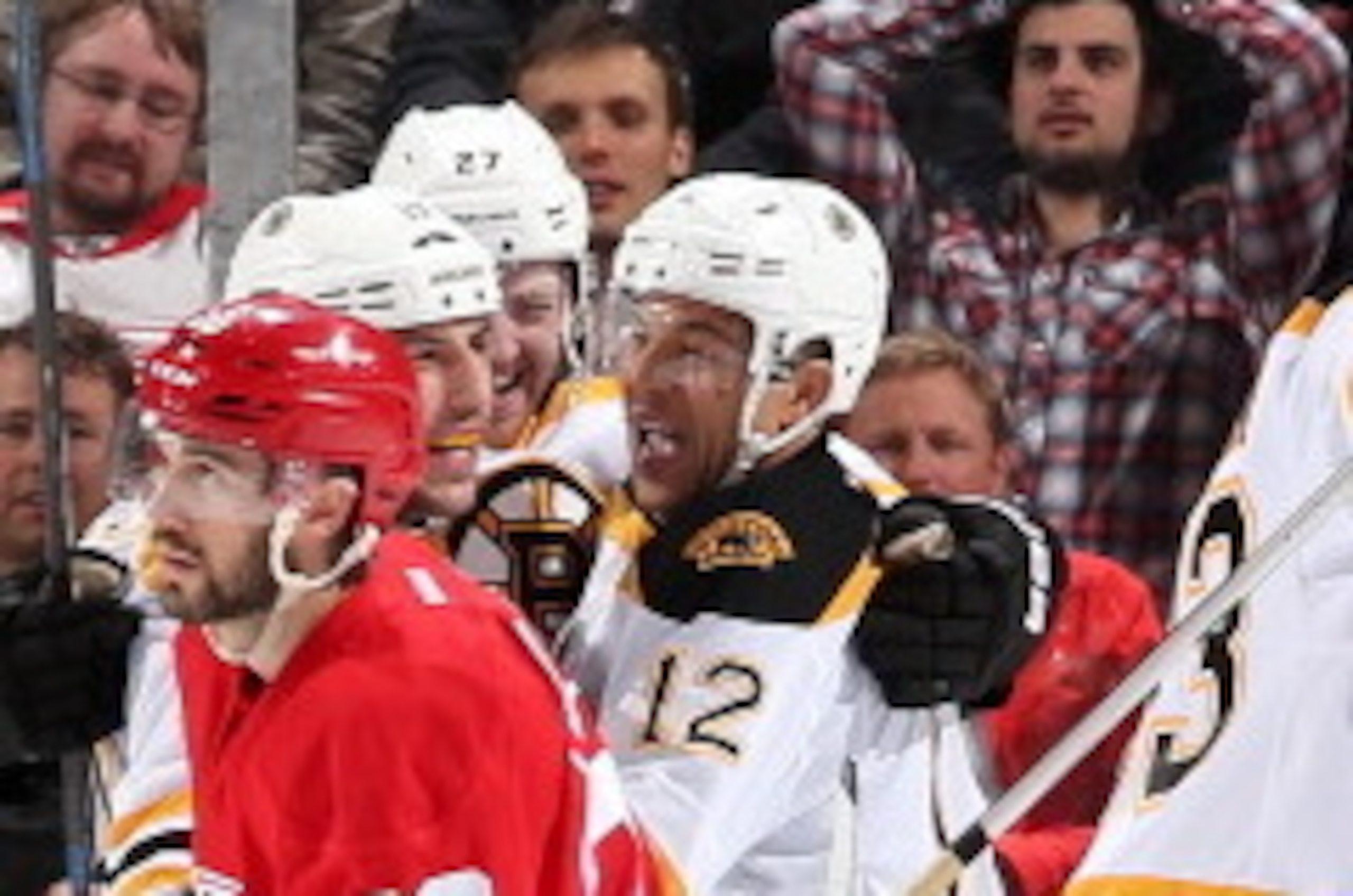 DETROIT, MI - APRIL 24:  Drew Miller #20 of the Detroit Red Wings skates away as members of the Boston Bruins celebrate with teammate Jarome Iginla #12 after scoring the game winning goal in overtime of Game Four of the First Round of the 2014 Stanley Cup