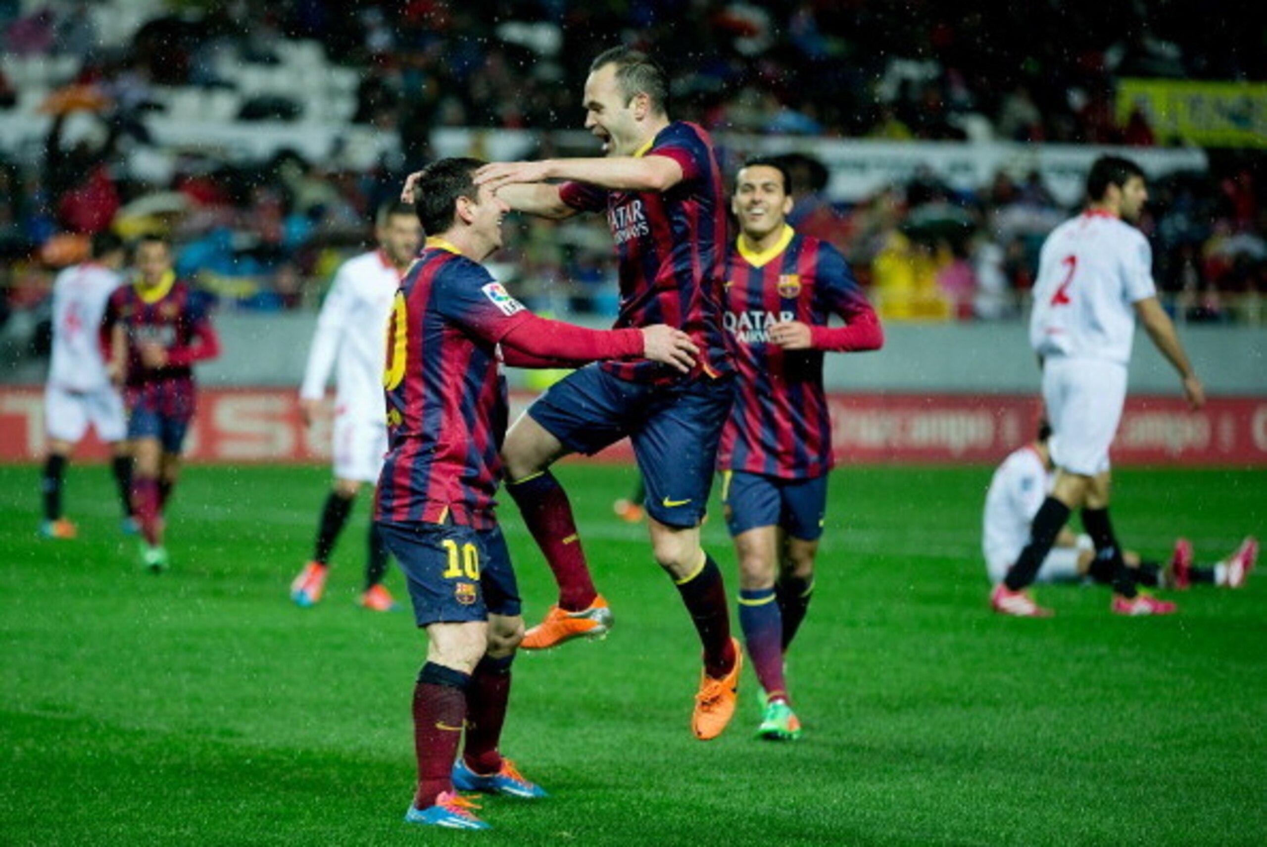 SEVILLE, SPAIN - FEBRUARY 09:  Lionel Messi (L) of FC Barcelona celebrates scoring their third goal with teammate Andres Iniesta (R) during the La Liga match between Sevilla FC and FC Barcelona at Estadio Ramon Sanchez Pizjuan on February 9, 2014 in Sevil