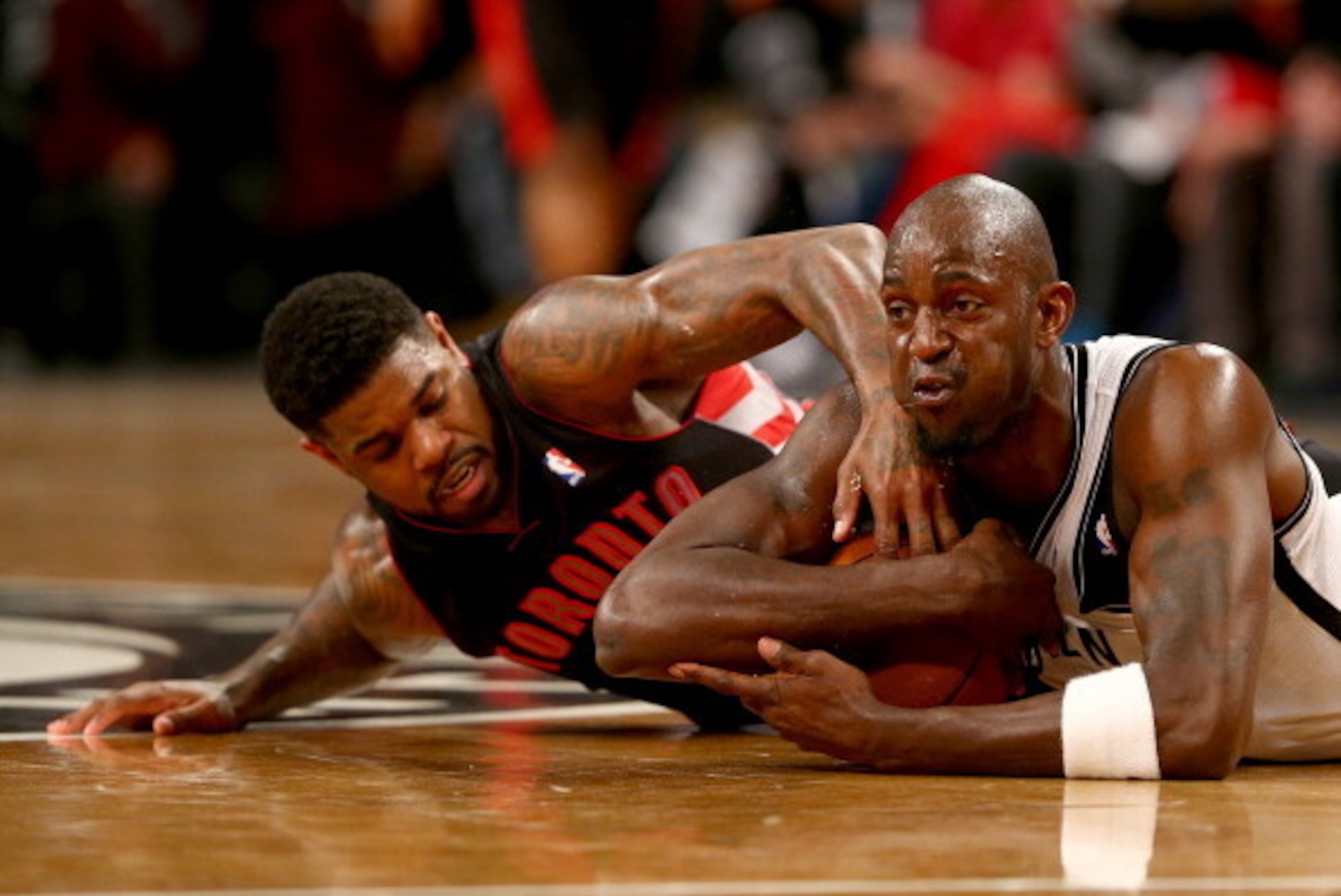 NEW YORK, NY - APRIL 25:  Kevin Garnett #2 of the Brooklyn Nets grabs the loose ball before Amir Johnson #15 of the Toronto Raptors in Game Three of the Eastern Conference Quarterfinals during the 2014 NBA Playoffs at the Barclays Center on April 25, 2014