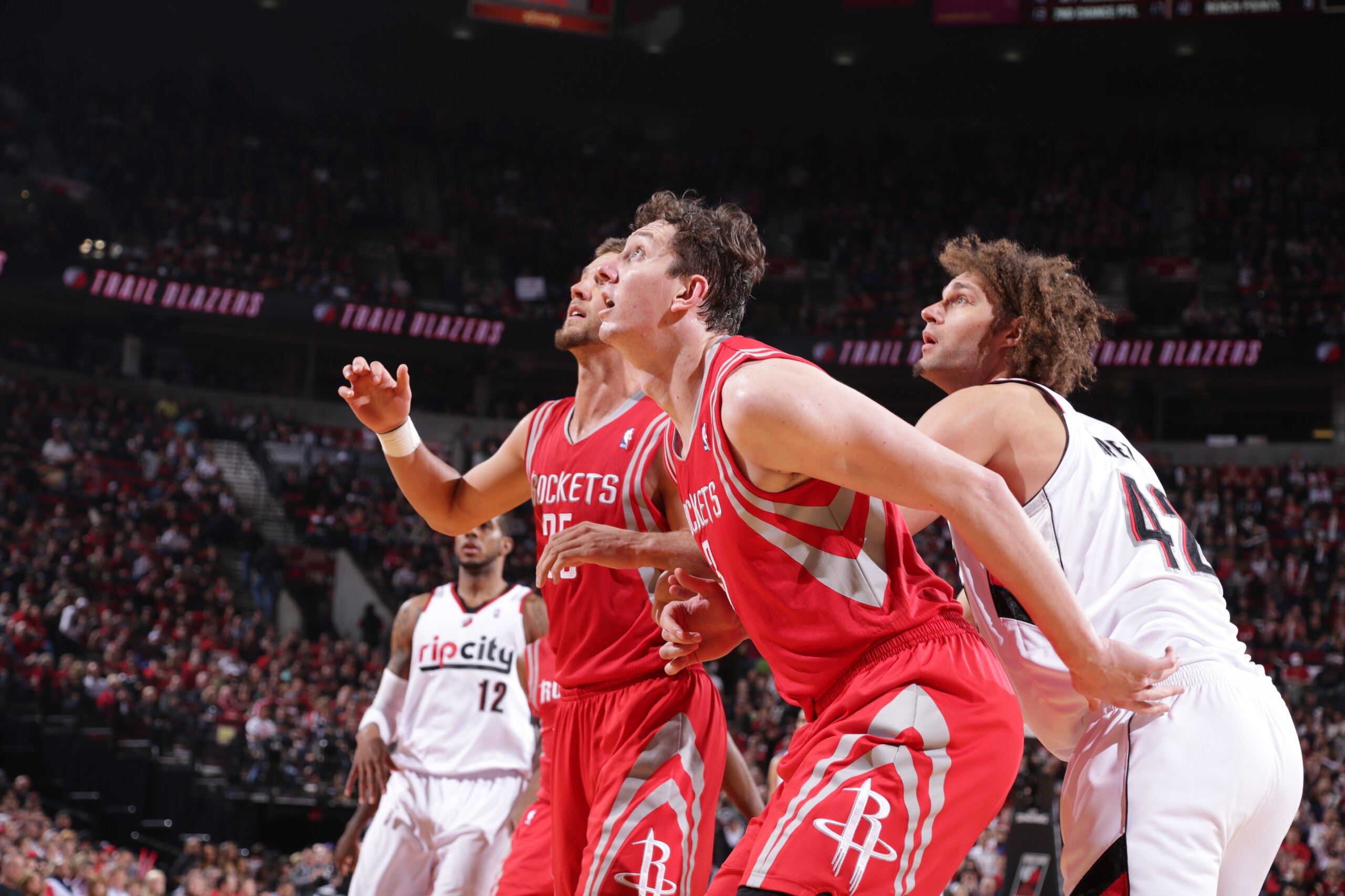 PORTLAND, OR - APRIL 25: Omer Asik #3 and Chandler Parsons #25 of the Houston Rockets battle for position against Robin Lopez #42 of the Portland Trail Blazers in Game Three of the Western Conference Quarterfinals during the 2014 NBA Playoffs on April 25,