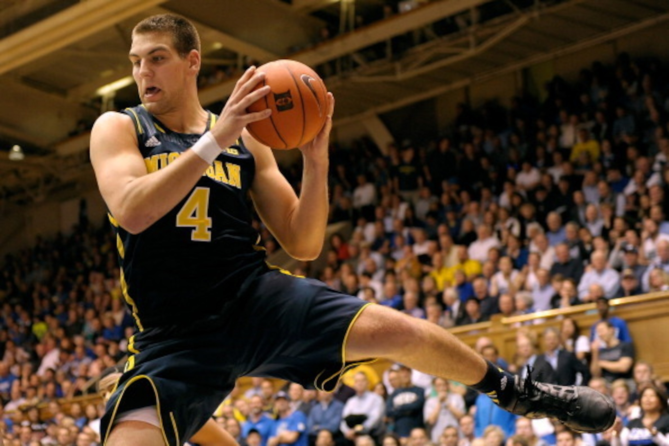 DURHAM, NC - DECEMBER 03:  Mitch McGary #4 of the Michigan Wolverines pulls down a rebound against the Duke Blue Devils at Cameron Indoor Stadium on December 3, 2013 in Durham, North Carolina. Duke won 79-69.  (Photo by Grant Halverson/Getty Images)