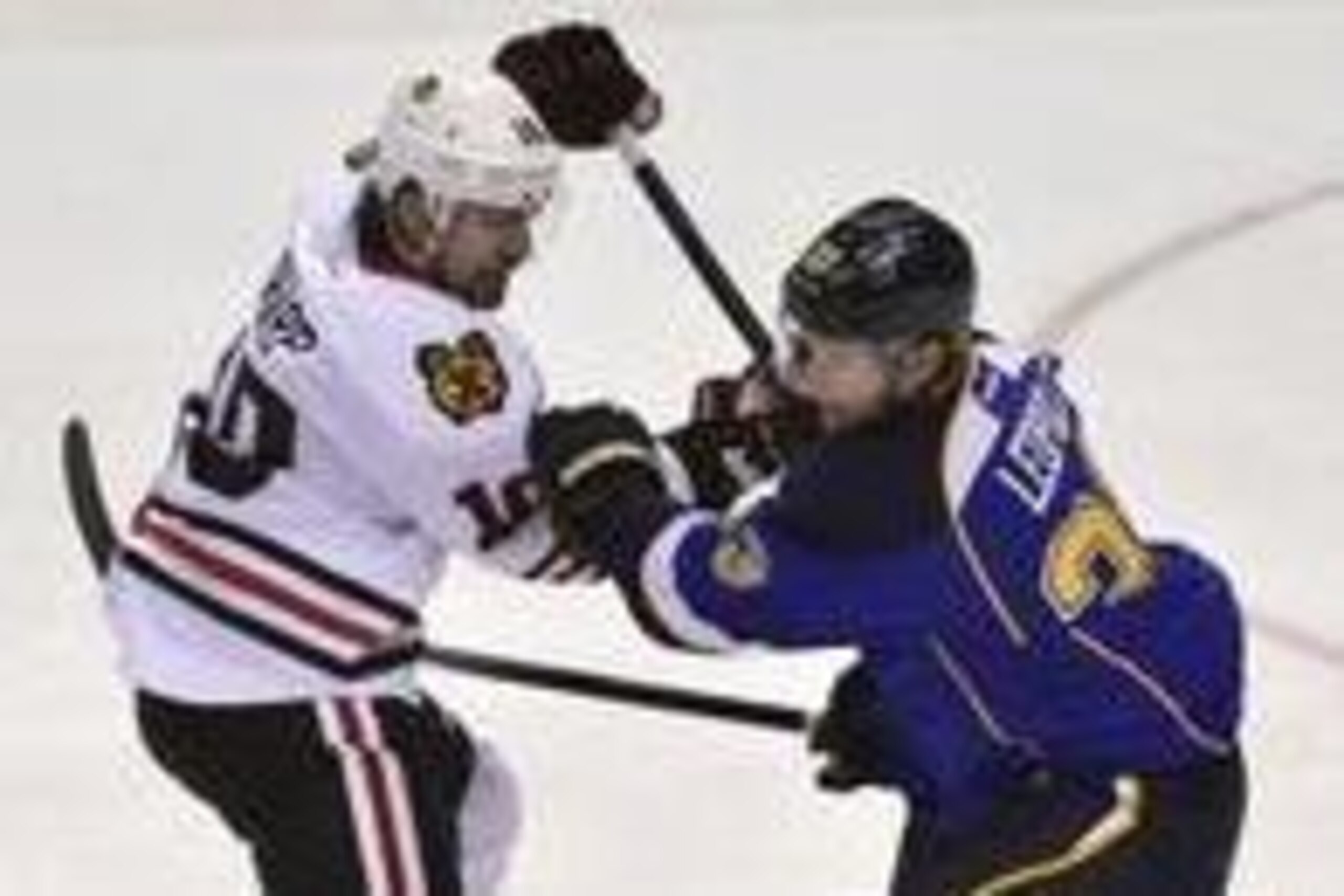 Apr 25, 2014; St. Louis, MO, USA; St. Louis Blues defenseman Jordan Leopold (33) defends against Chicago Blackhawks left wing Patrick Sharp (10) during the third period in game five of the first round of the 2014 Stanley Cup Playoffs at Scottrade Center. 