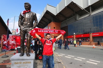 LIVERPOOL, ENGLAND - APRIL 27:  A Liverpool fan poses for a photo with a statue of former Manchester United manager David Moyes is seen ahead of the Barclays Premier League match between Liverpool and Chelsea at Anfield on April 27, 2014 in Liverpool, Eng