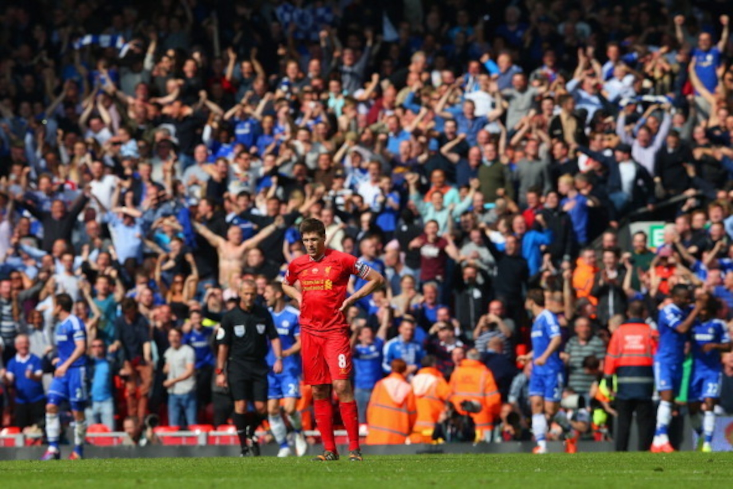 LIVERPOOL, ENGLAND - APRIL 27:  A dejected Steven Gerrard of Liverpool looks on as the Chelsea fans celebrate after Willian of Chelsea scored their second goal during the Barclays Premier League match between Liverpool and Chelsea at Anfield on April 27, 