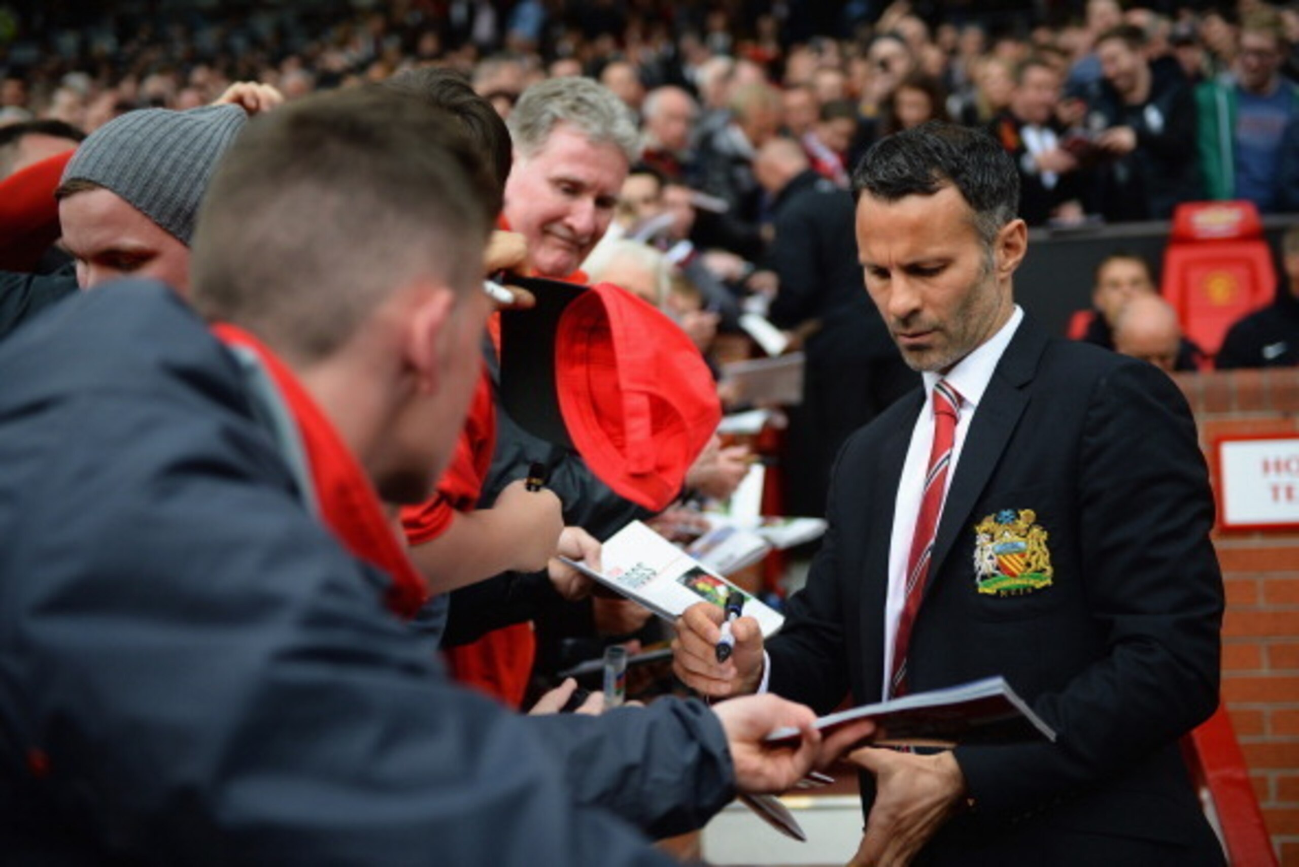 MANCHESTER, ENGLAND - APRIL 26: Ryan Giggs of Manchester United signs autographs during the Barclays Premier League match between Manchester United and Norwich City at Old Trafford on April 26, 2014 in Manchester, England. (Photo by Laurence Griffiths/G MANCHESTER, ENGLAND - APRIL 26: Ryan Giggs of Manchester United signs autographs during the Barclays Premier League match between Manchester United and Norwich City at Old Trafford on April 26, 2014 in Manchester, England. (Photo by Laurence Griffiths/G