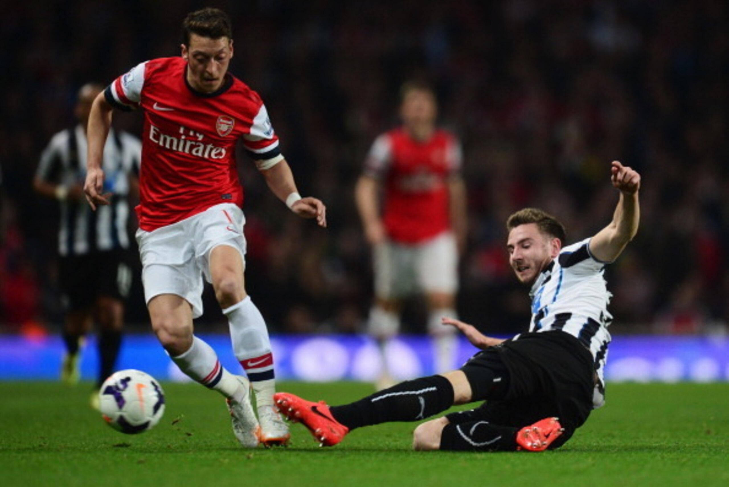 LONDON, ENGLAND - APRIL 28:  Paul Dummett of Newcastle United tackles Mesut Oezil of Arsenal during the Barclays Premier League match between Arsenal and Newcastle United at Emirates Stadium on April 28, 2014 in London, England.  (Photo by Jamie McDonald/