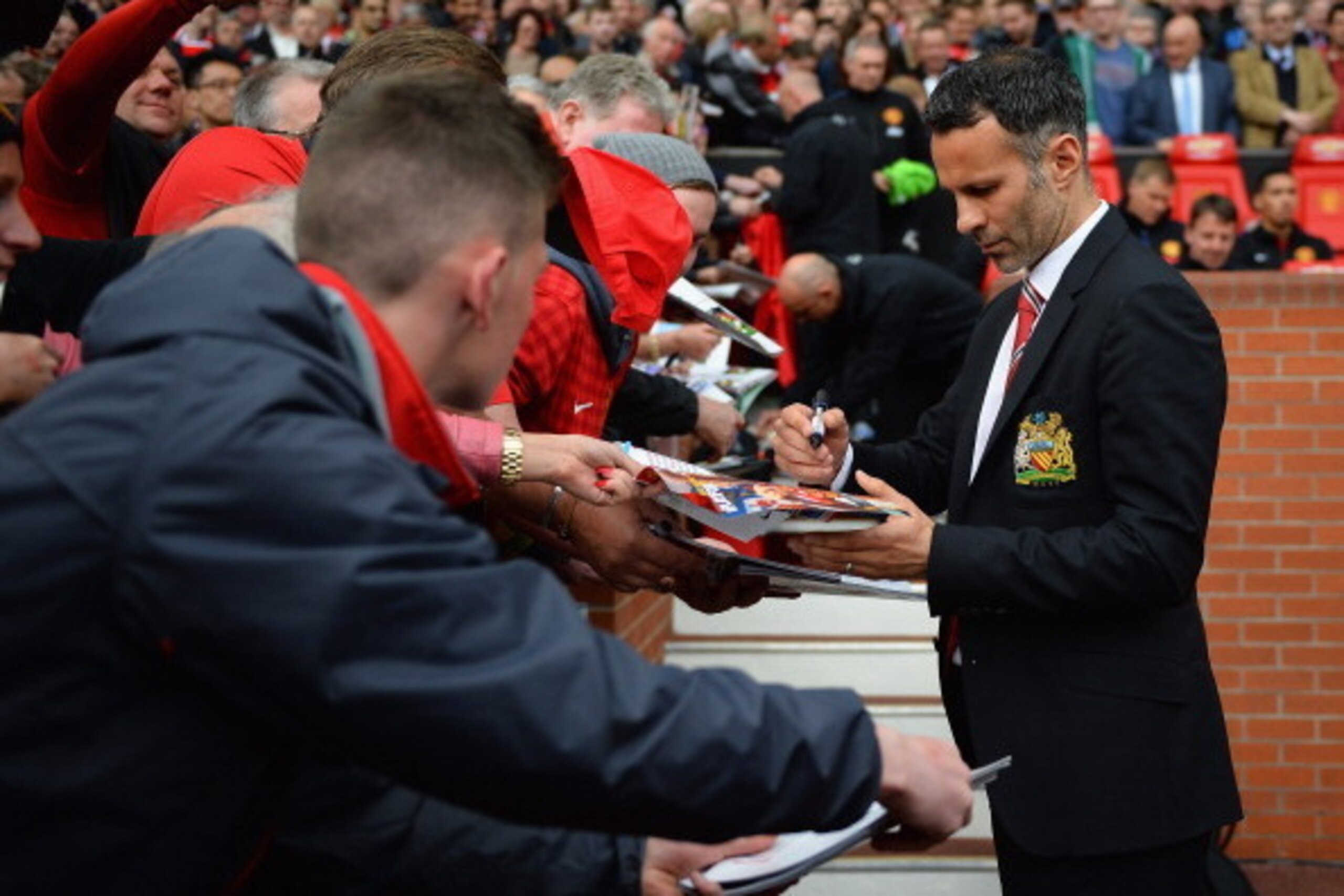 MANCHESTER, ENGLAND - APRIL 26:  Ryan Giggs of Manchester United signs autographs during the Barclays Premier League match between Manchester United and Norwich City at Old Trafford on April 26, 2014 in Manchester, England.  (Photo by Laurence Griffiths/G
