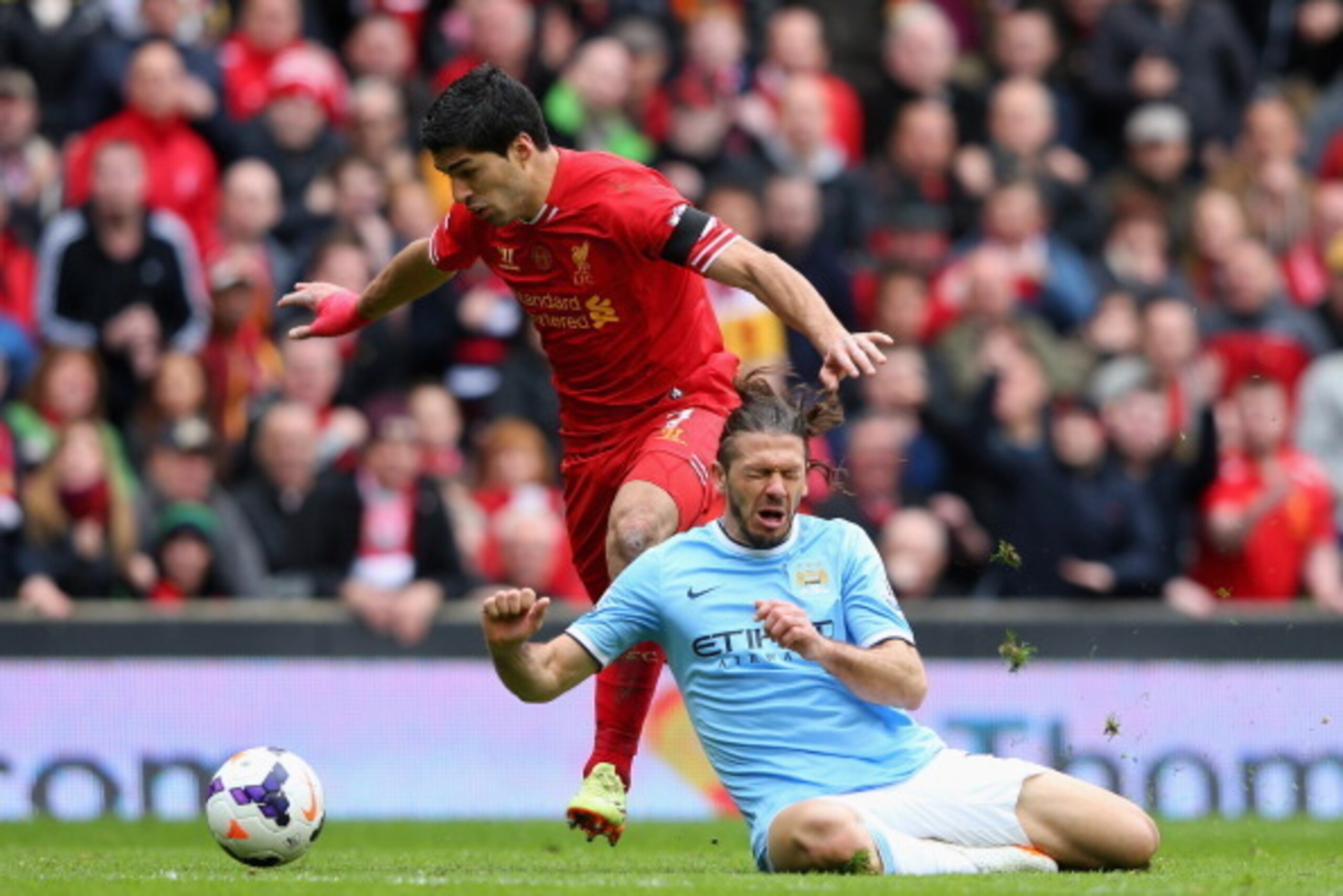 LIVERPOOL, ENGLAND - APRIL 13:  Luis Suarez of Liverpool tangles with Martin Demichelis of Manchester City during the Barclays Premier League match between Liverpool and Manchester City at Anfield on April 13, 2014 in Liverpool, England.  (Photo by Alex L