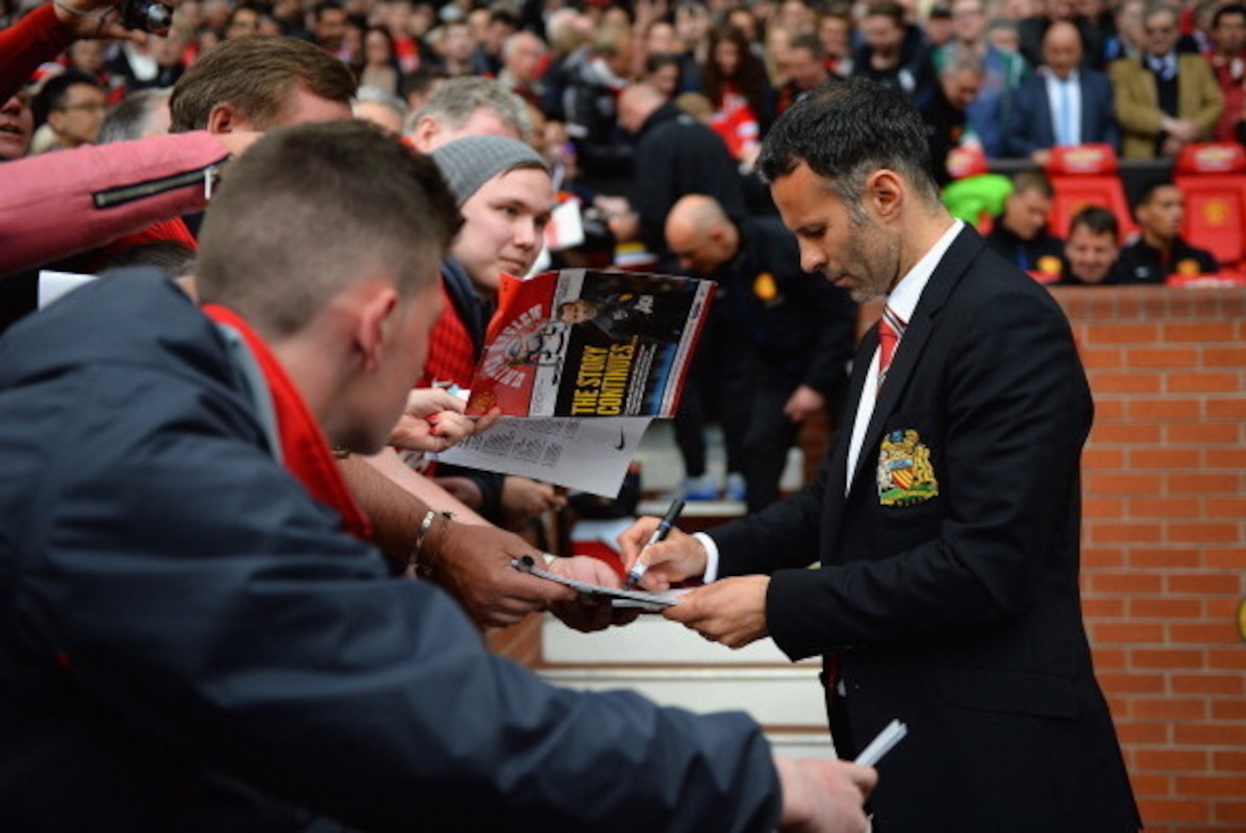 MANCHESTER, ENGLAND - APRIL 26:  Ryan Giggs of Manchester United signs autographs during the Barclays Premier League match between Manchester United and Norwich City at Old Trafford on April 26, 2014 in Manchester, England.  (Photo by Laurence Griffiths/G