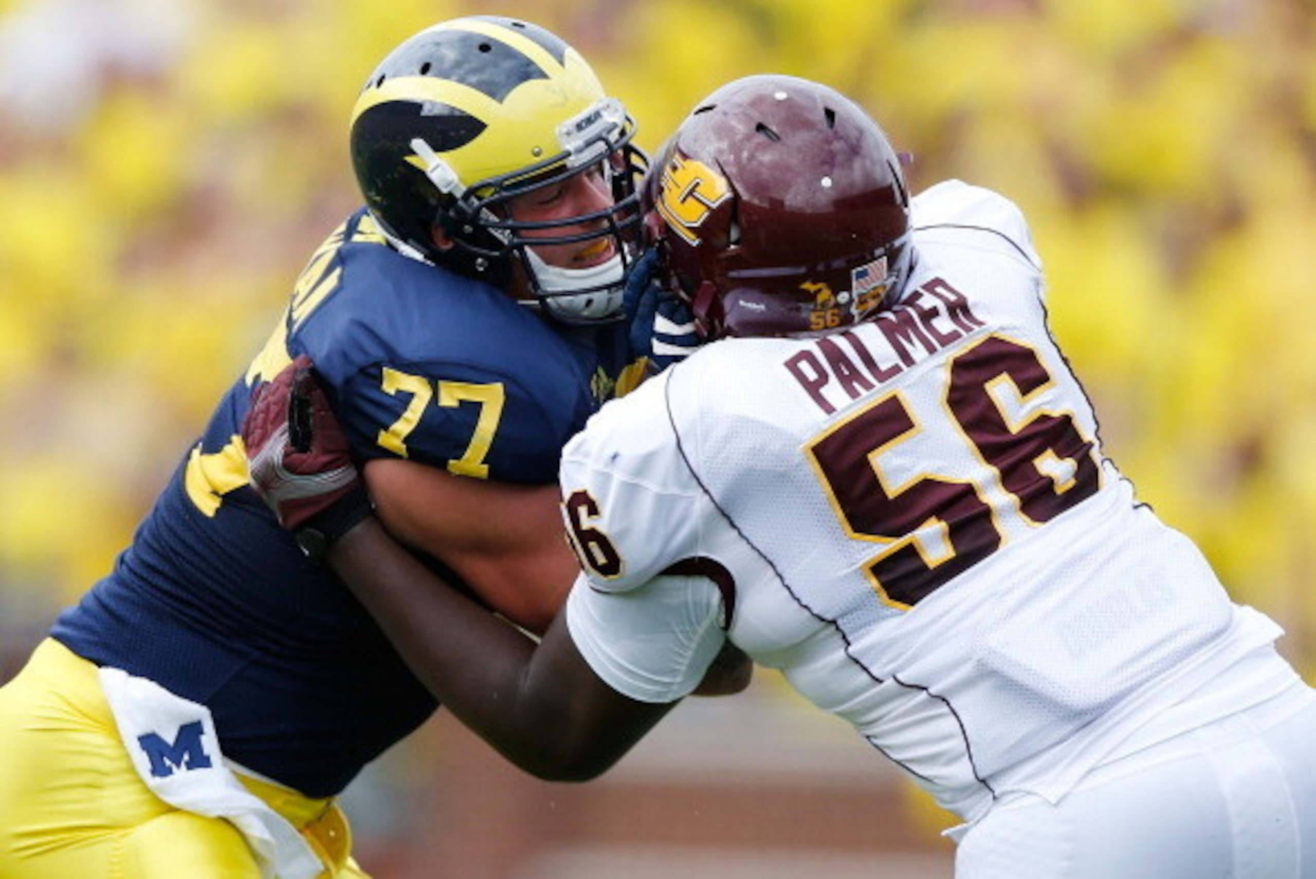 ANN ARBOR, MI - AUGUST 31: Taylor Lewan #77 of the Michigan Wolverines block the pass rush of Louis Palmer #56 of the Central Michigan Chippewas during the first quarter at Michigan Stadium on August 31, 2013 in Ann Arbor, Michigan.  (Photo by Gregory Sha