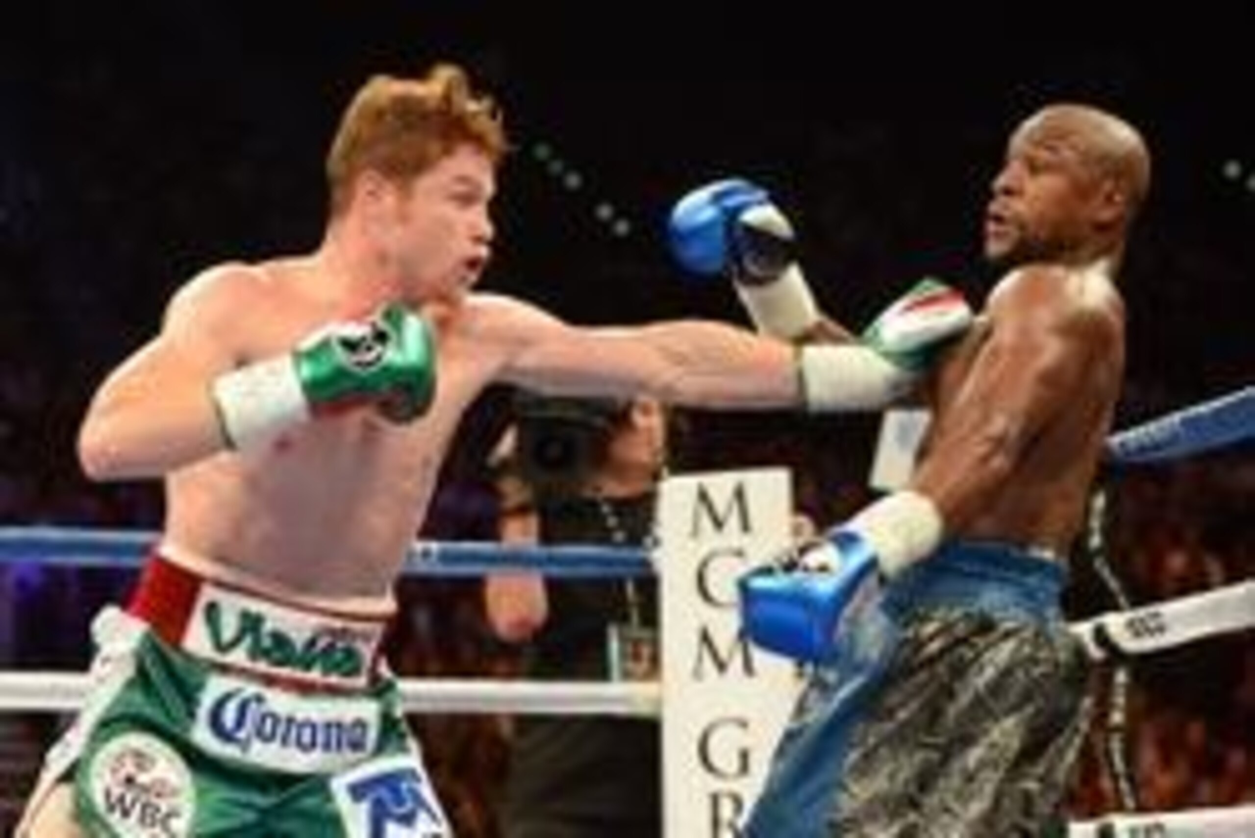 Sep 14, 2013; Las Vegas, NV, USA; Floyd Mayweather Jr. (blue gloves) and Canelo Alvarez battle it during their during their WBC and WBA super welterweight titles fight at MGM Grand Garden Arena. Mandatory Credit: Jayne Kamin-Oncea-USA TODAY Sports