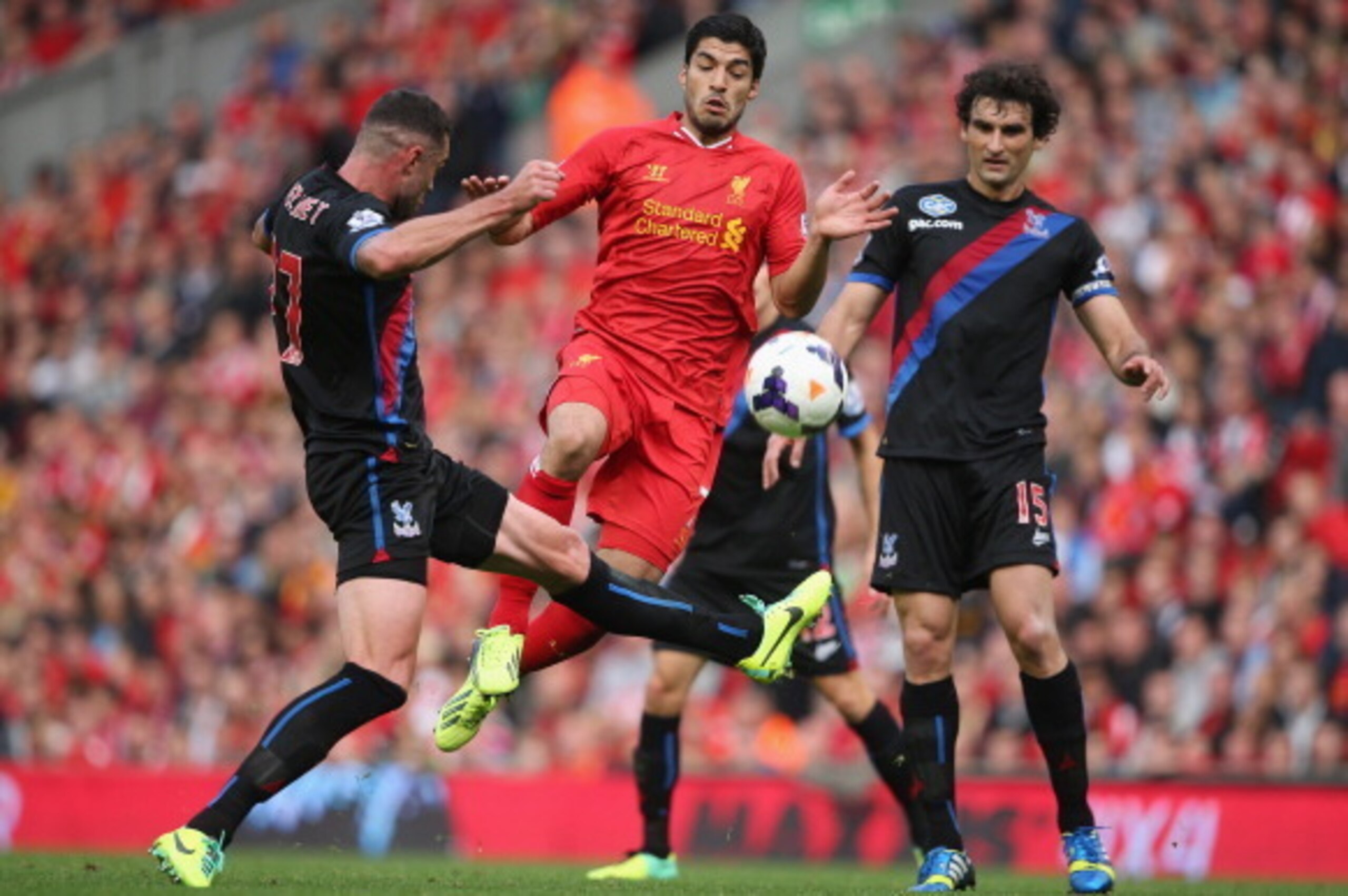 LIVERPOOL, ENGLAND - OCTOBER 05:  Luis Suarez of Liverpool in action with Damien Delaney and Mile Jedinak of Crystal Palace during the Barclays Premier League match between Liverpool and Crystal Palace at Anfield on October 5, 2013 in Liverpool, England. 